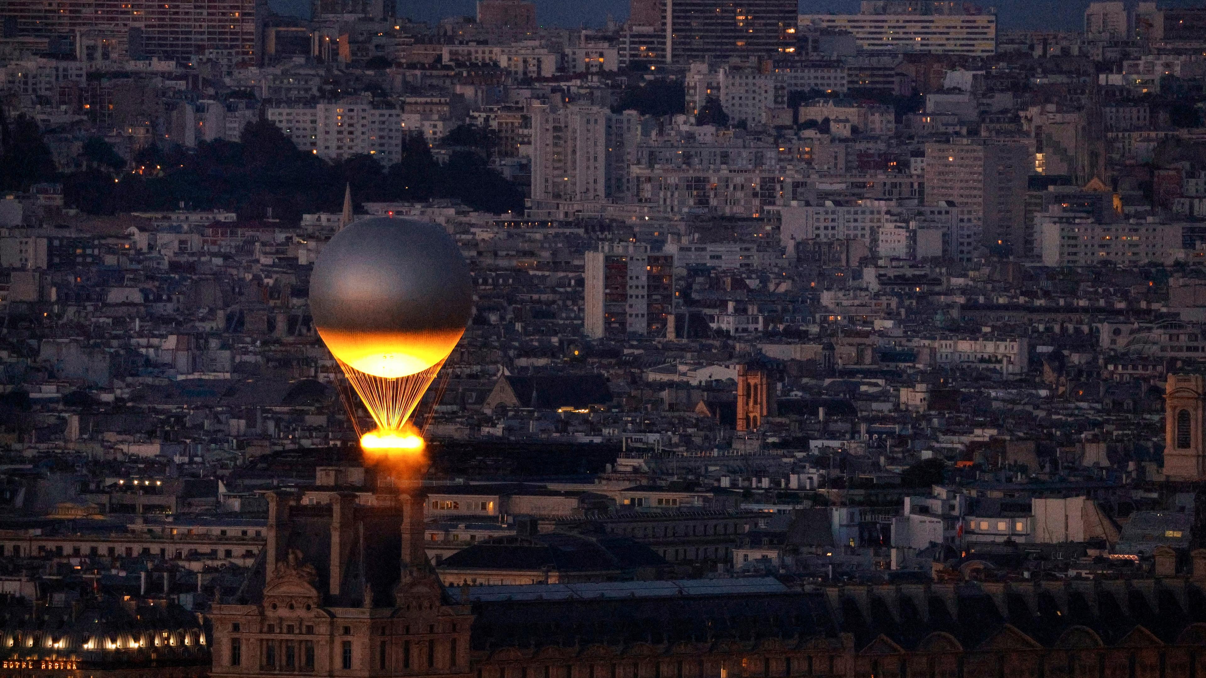 Der Kessel mit dem Olympischen Feuer fliegt an einem Ballon befestigt über Paris, vom Eiffelturm aus gesehen.