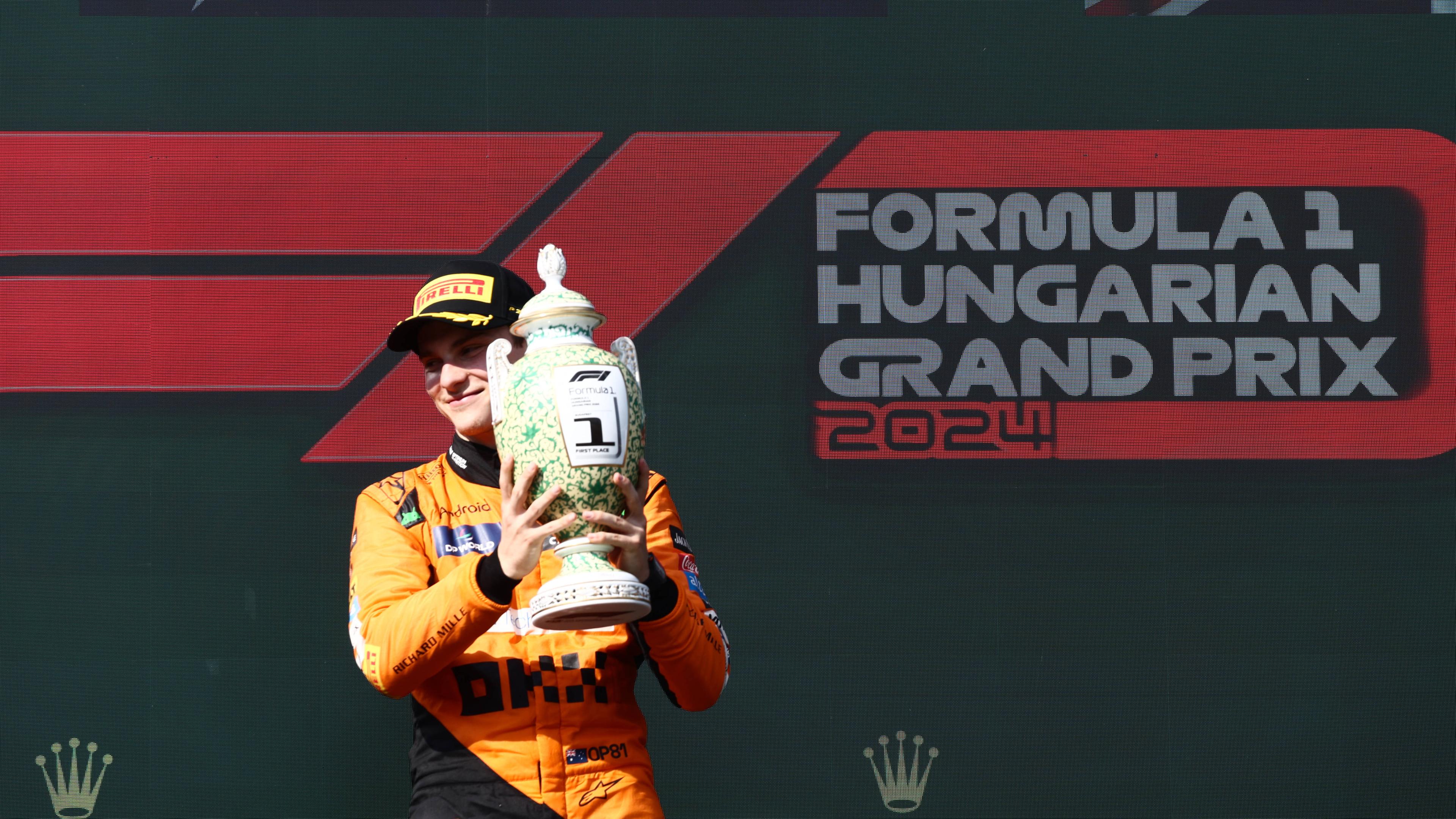 Oscar Piastri gewinnt das Rennen des Grand Prix in Ungarn und hält den Pokal in den Händen.