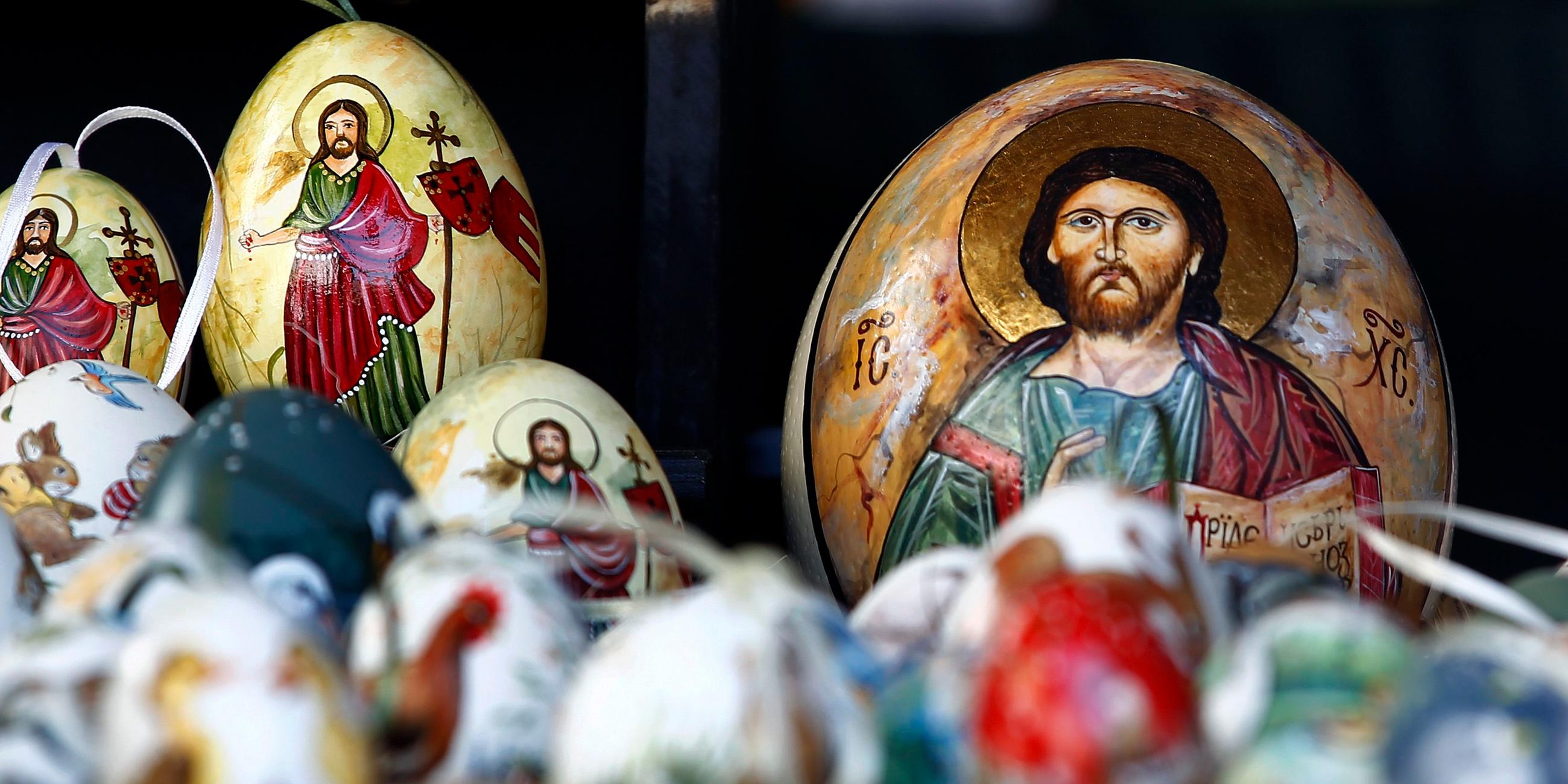 Kunstvoll bemalte Ostereier liegen in der Auslage eines Standes auf einem Ostermarkt in Bad Tölz. Die Eier sind mit kirchlichen Ostermotiven verziert.