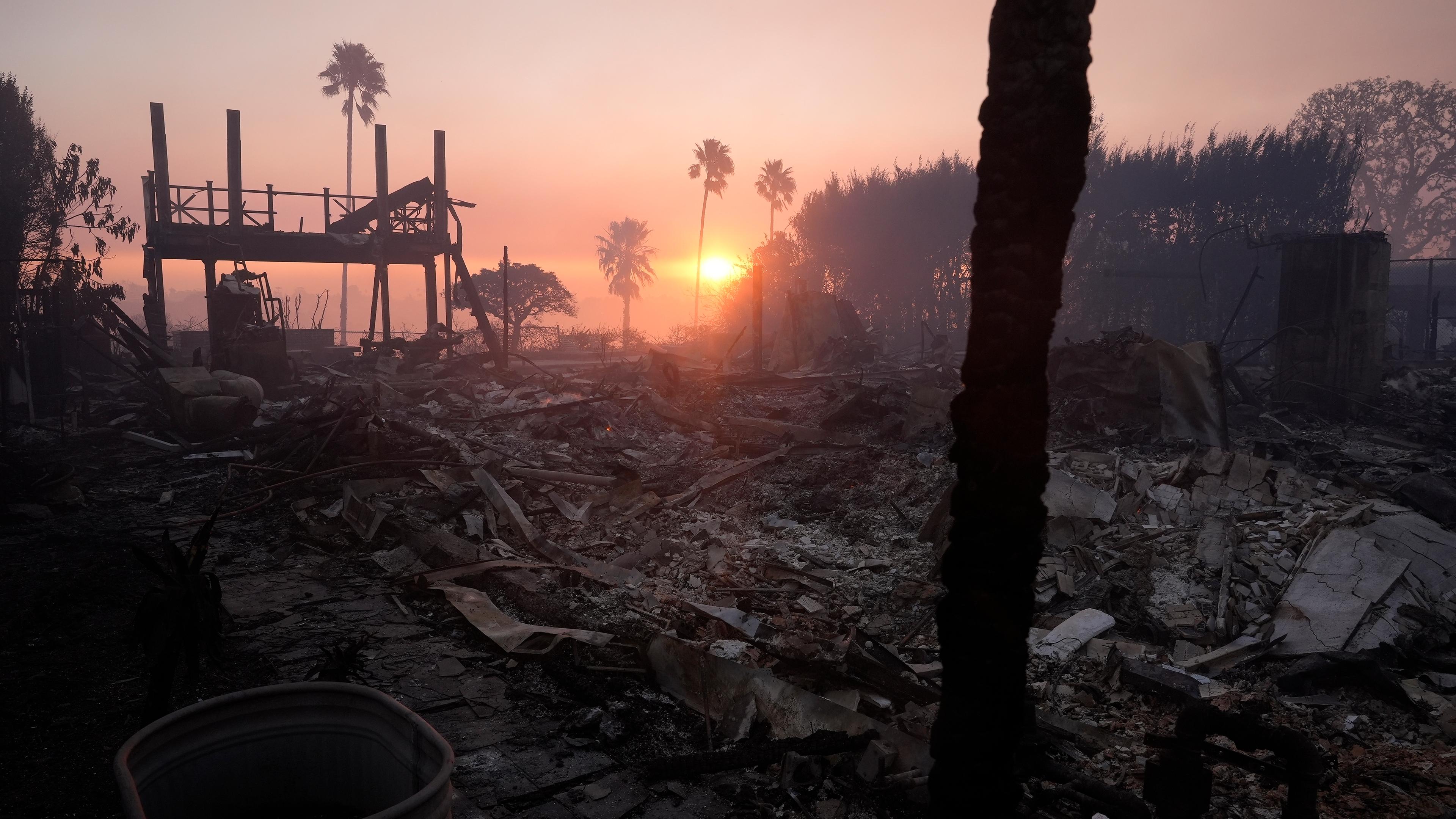 Überreste eines abgebrannten Hauses im verrauchten Sonnenaufgang.