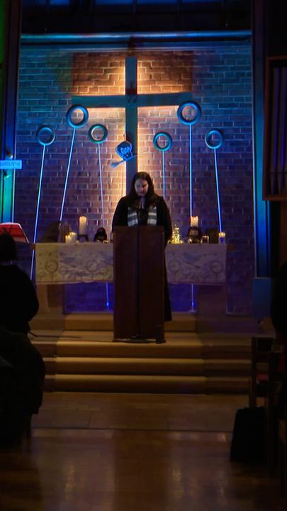 Pfarrer bei Predigt in abgedunkelter Kirche links im Bild. Rechts steht eine Person in Hogwarts-Umhang vor einem Kreuz und Quidditch-Ringen aus den Harry-Potter-Büchern.