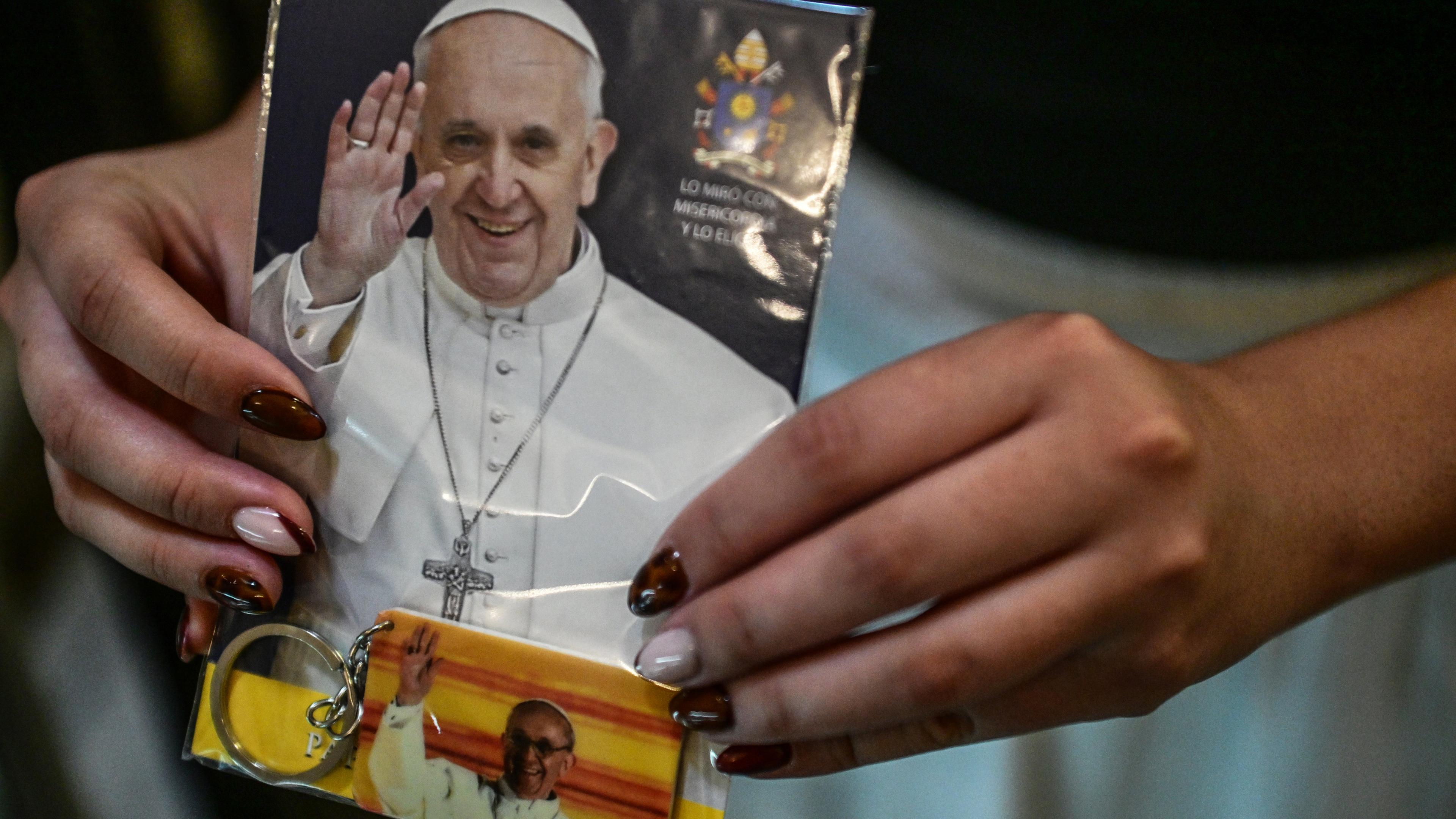 Argentinien, Buenos Aires: Eine Frau hält ein Foto in der Hauptkirche von Buenos Aires bei einer Messe für die Gesundheit von Papst Franziskus.