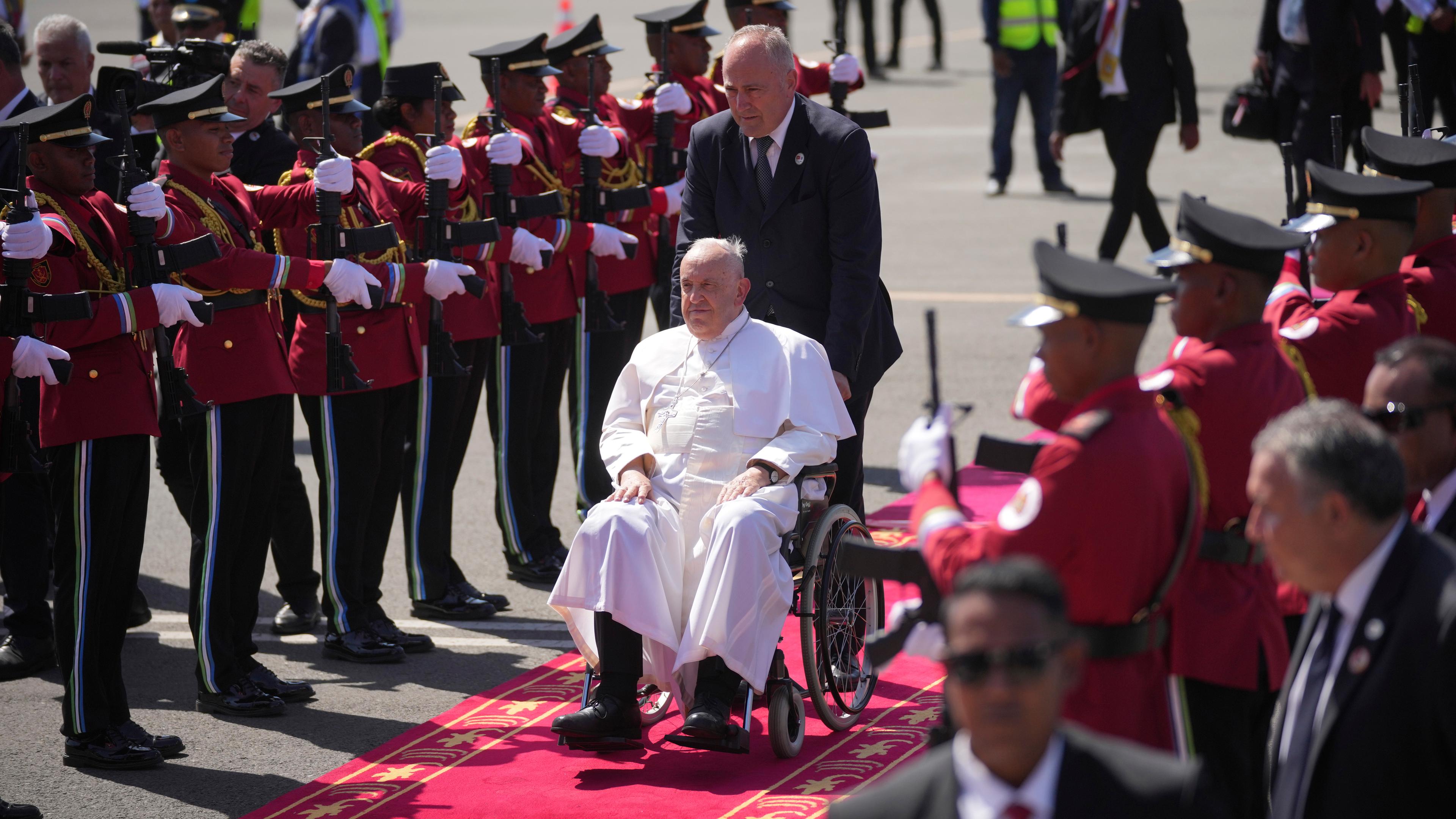 09.09.2024, Osttimor, Dili: Papst Franziskus wird nach seiner Ankunft auf einem roten Teppich von Mitgliedern der Ehrengarde empfangen.