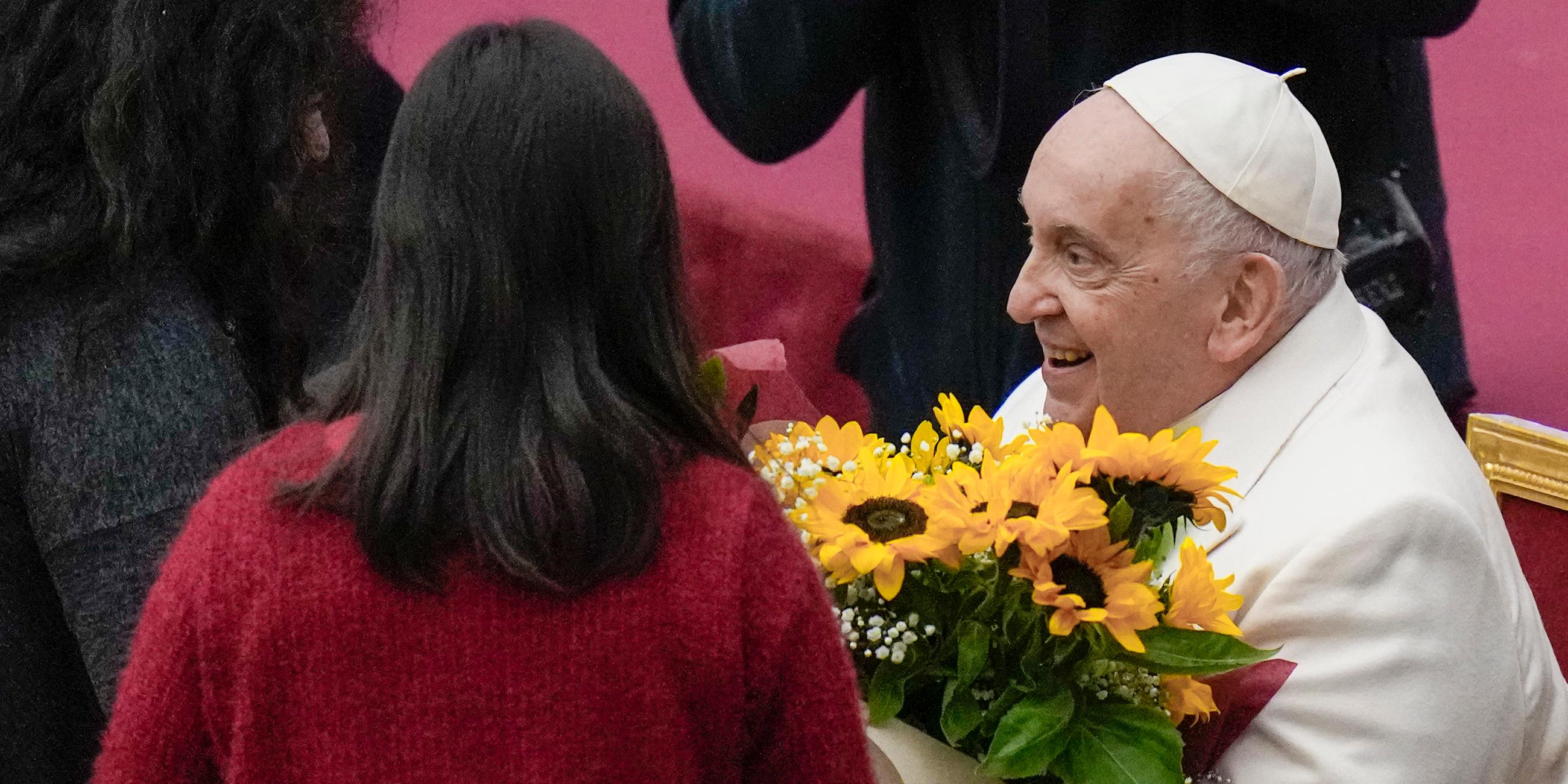 17.12.2023, Vatikan, Vatikanstadt: Papst Franziskus wird von Jugendlichen begrüßt, als er während einer Audienz in der Paul VI.-Halle seinen Geburtstag mit Kindern feiert, die von der Krankenstation Santa Marta betreut werden. 