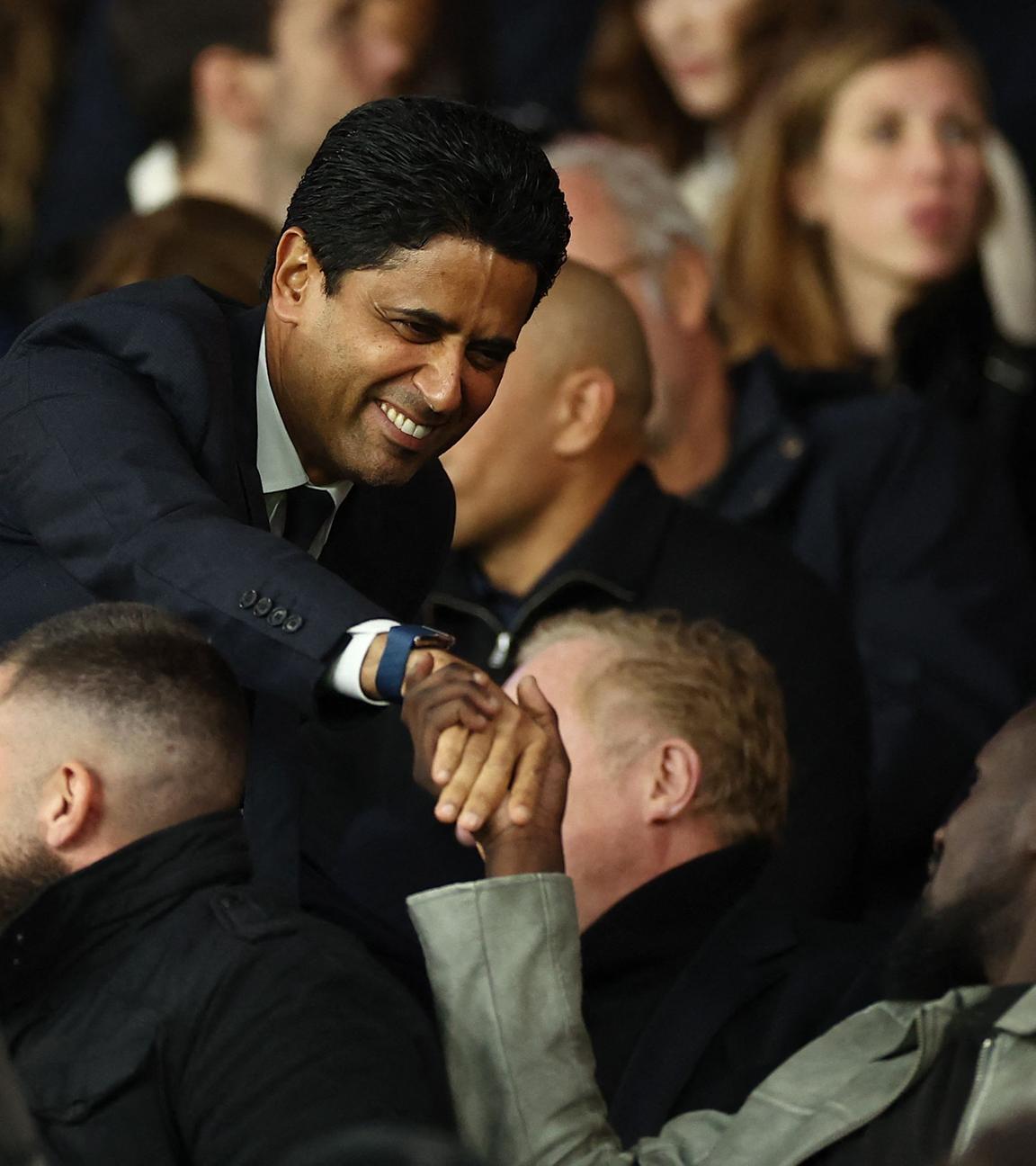 Paris-Saint-Germain-Chef Nasser Al-Khelaifi (links) begrüßt beim Spiel Paris Saint-Germain - Stade Rennes einen anderen Tribünengast per Handschlag