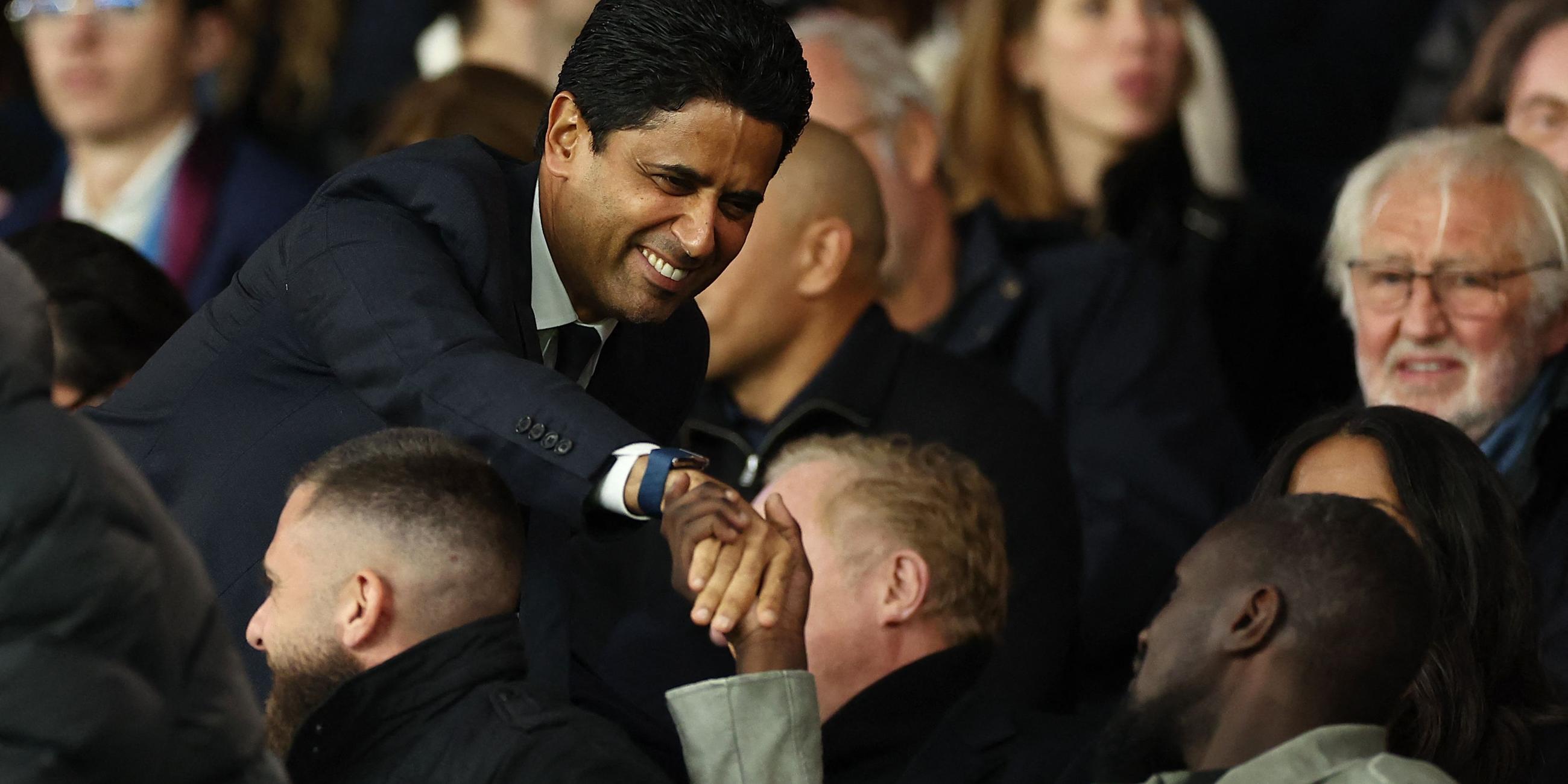 Paris-Saint-Germain-Chef Nasser Al-Khelaifi (links) begrüßt beim Spiel Paris Saint-Germain - Stade Rennes einen anderen Tribünengast per Handschlag