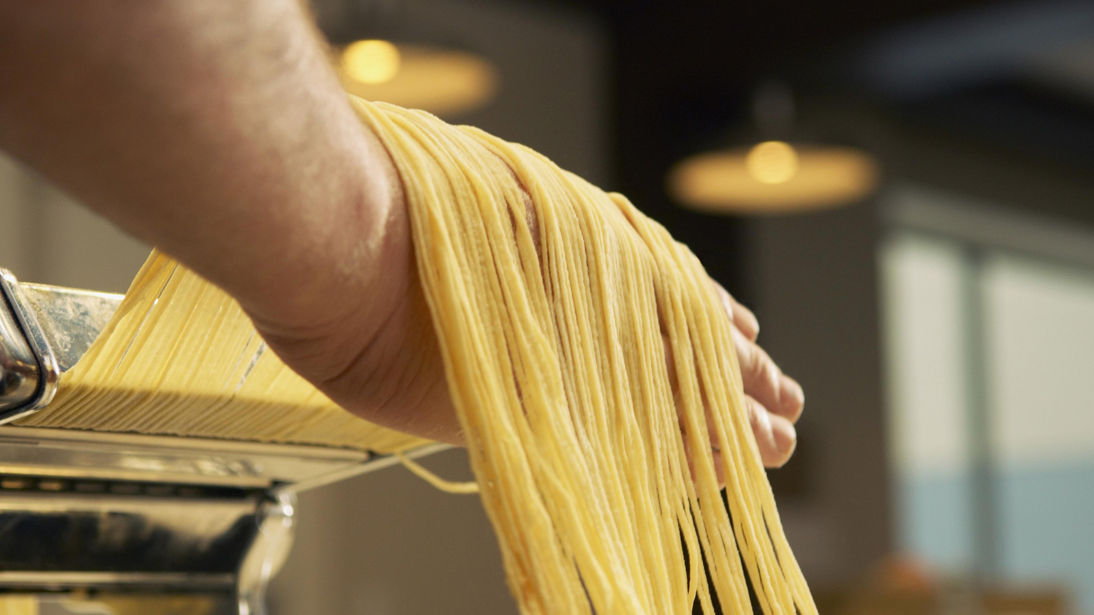 Spaghetti werden mit einer Nudelmaschine hergestellt.