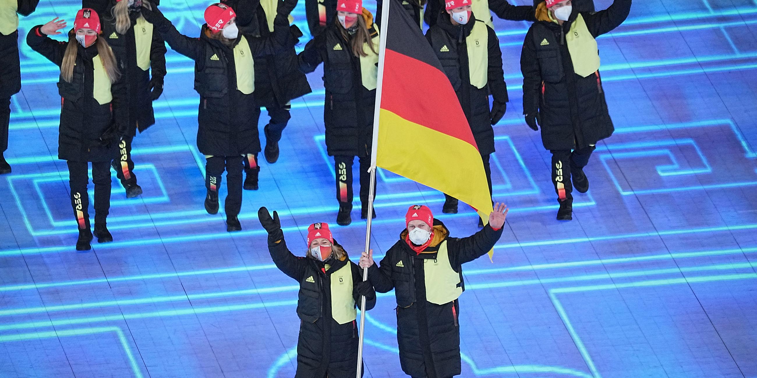 Die deutschen Fahnenträger Francesco Friedrich und Claudia Pechstein laufen mit den deutschen Teilnehmern ein am 04.02.2022 in Beijing.