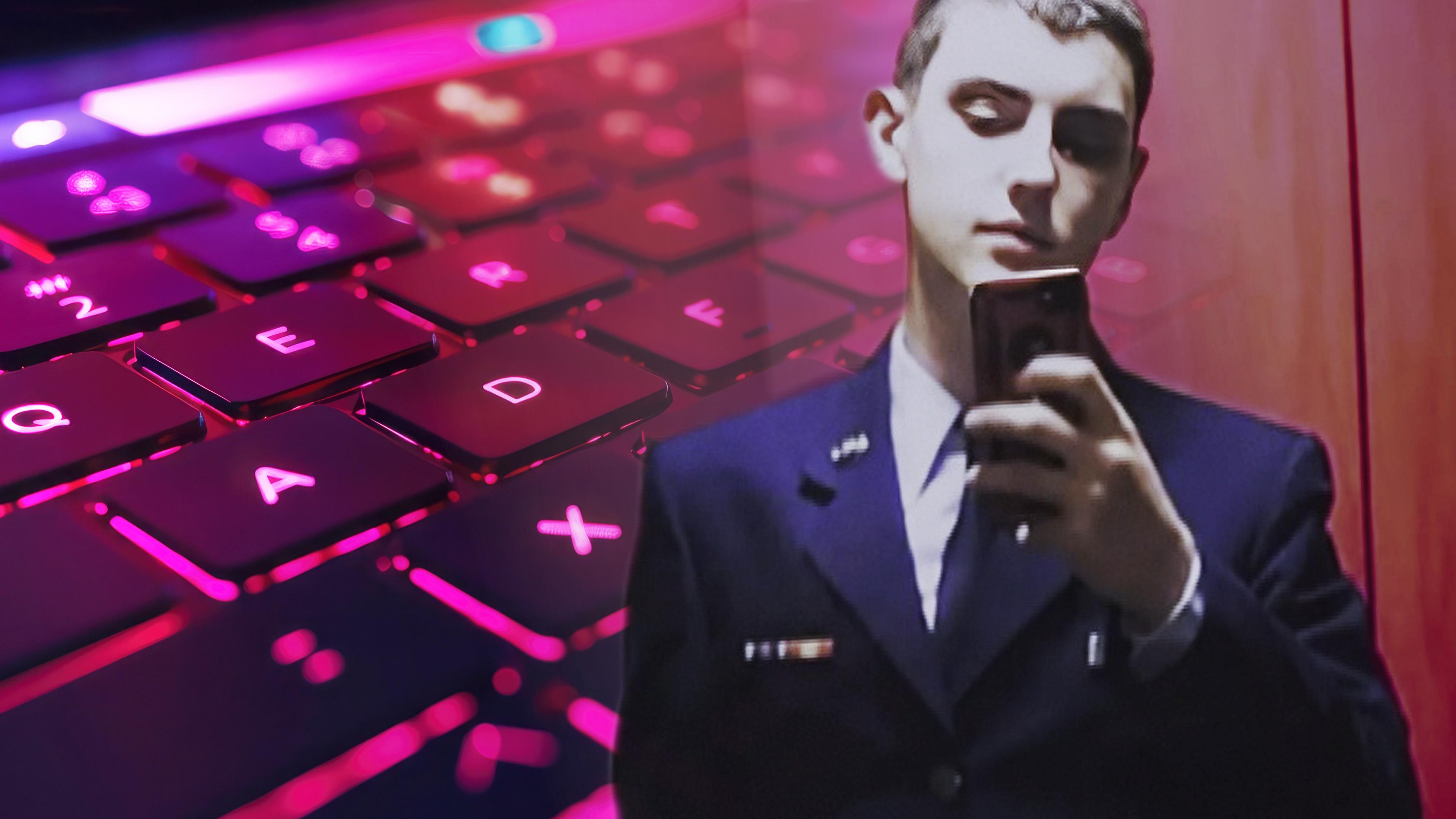 Ein junger Mann im Anzug blickt auf sein Smartphone; im Hintergrund eine Tastatur im pinke Licht.