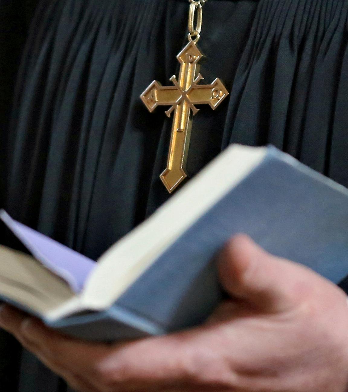 Pfarrer hält Bibel in der Hand