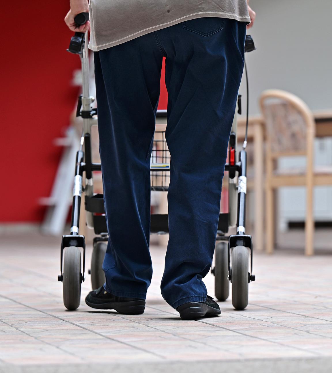 Ein Bewohner eines Pflegezentrums geht mit dem Rollator durchs Haus (Archivbild)