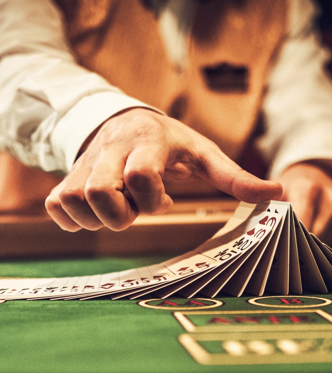 Nahaufnahme auf die Hände eines Croupiers. Sie mischen im Casino geübt Karten.