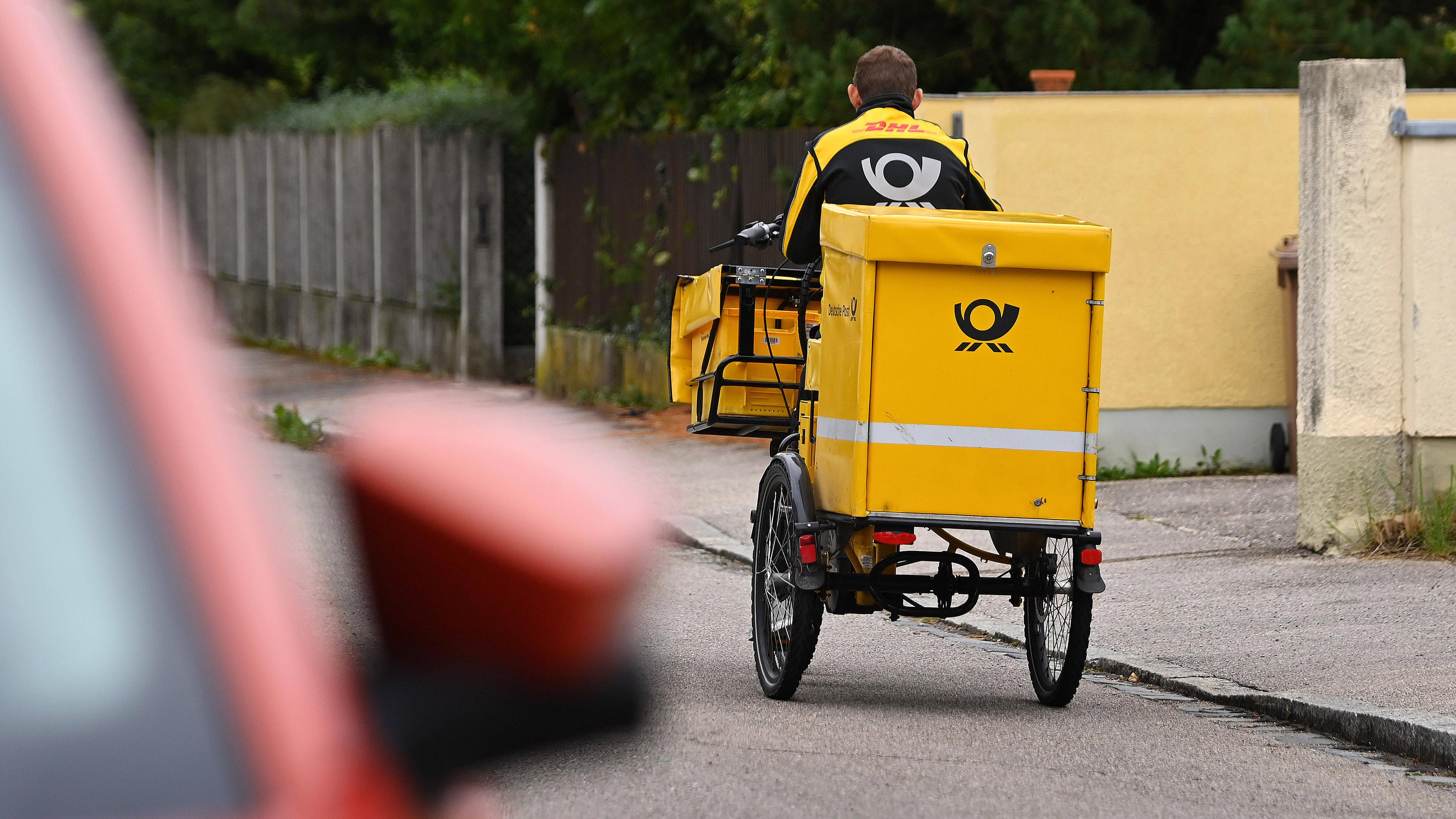 Postbote bei Postzustellung mit dem Fahrrad