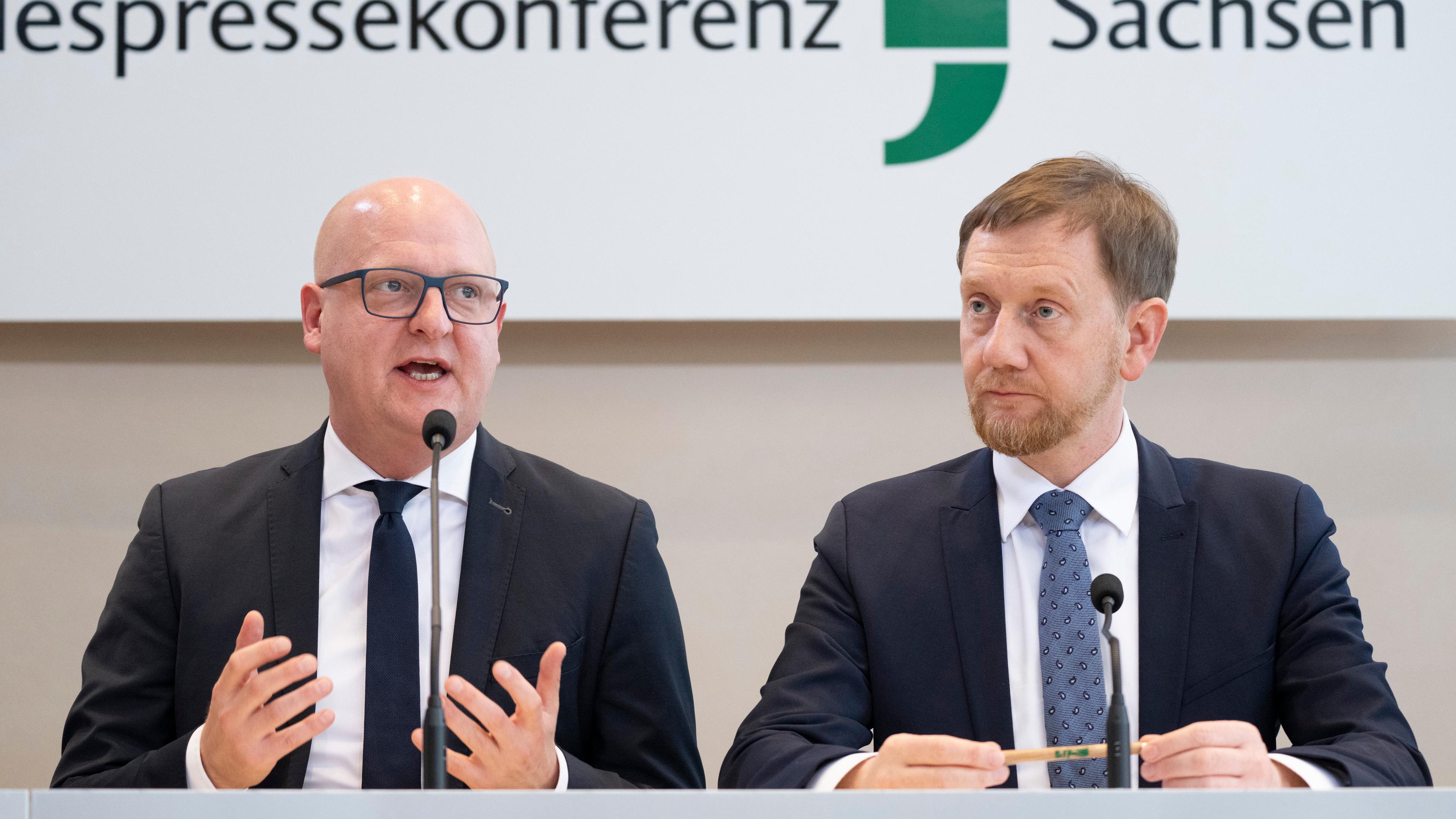 Henning Homann (l), Co-Vorsitzender der SPD in Sachsen, und Michael Kretschmer (CDU), Ministerpräsident von Sachsen, nehmen an einer Pressekonferenz im Landtag teil.