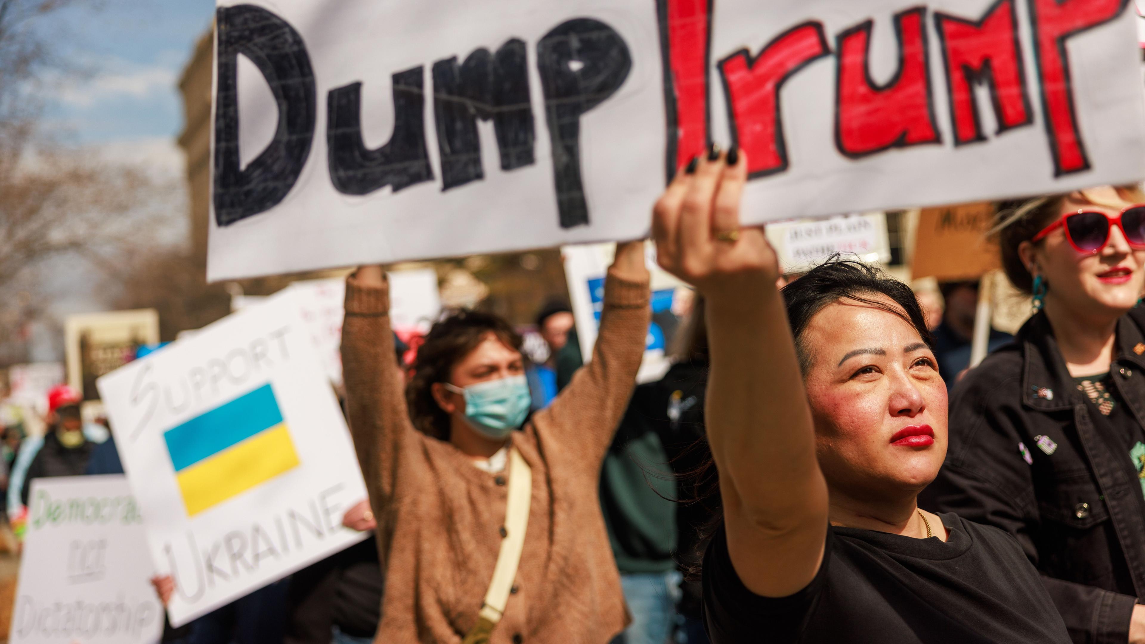 Eine Demonstrantin hält bei einem Anti-Trump-Protest ein Plakat mit der Aufschrift "Dump Trump" nach oben.