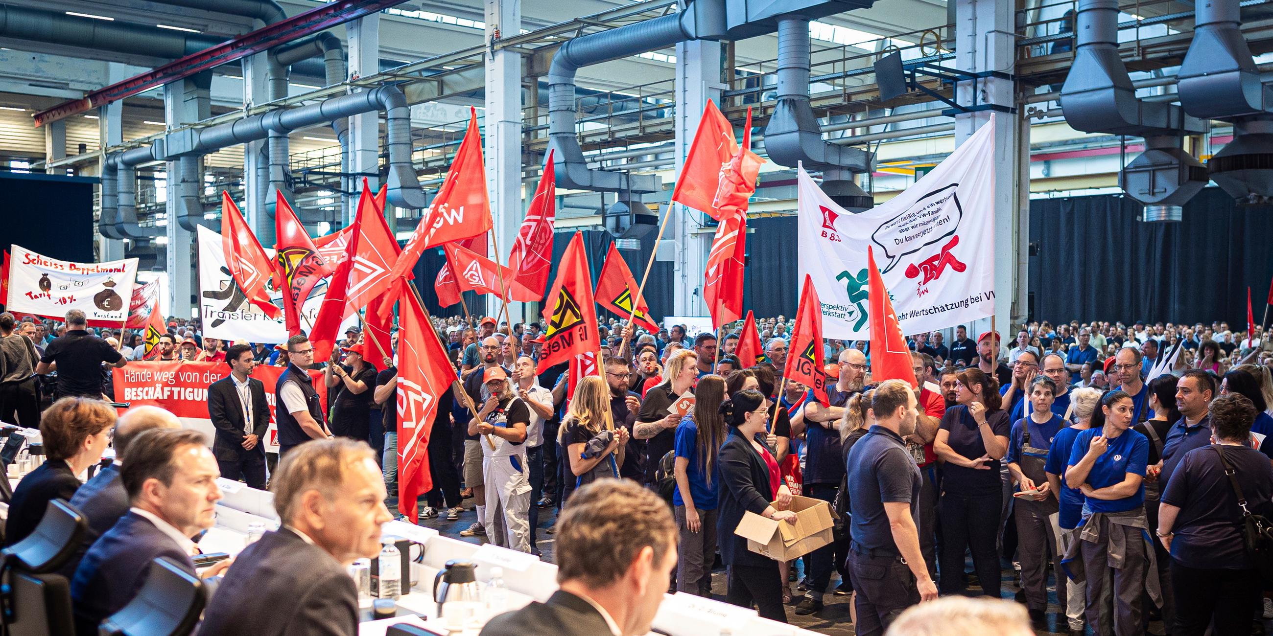 Employees protest before the start of a works meeting in a hall at the VW plant in Wolfsburg, Wednesday, Sept. 4, 2024. Volkswagen has announced that it will tighten its austerity measures due to the tense situation of the core brand. Redundancies and plant closures can no longer be ruled out.