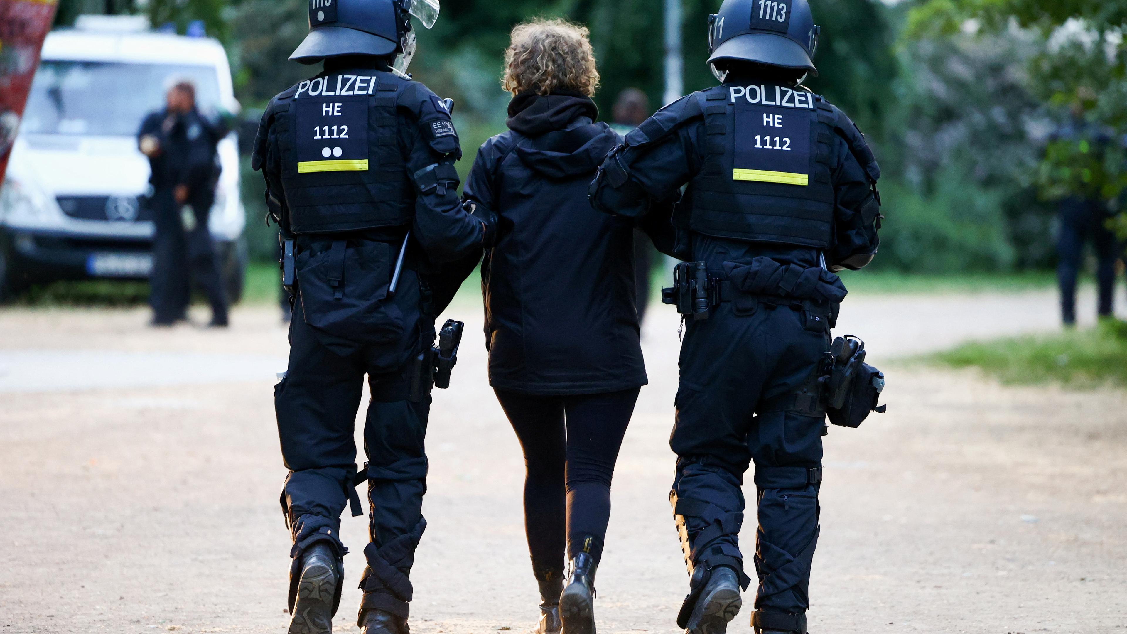 Polizisten setzen eine Person beim Protest in Leipzig fest