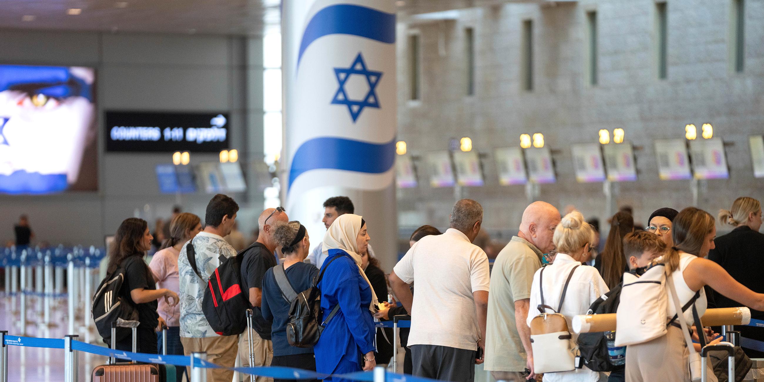 Reisende stehen am internationalen Flughafen Ben Gurion Schlange.