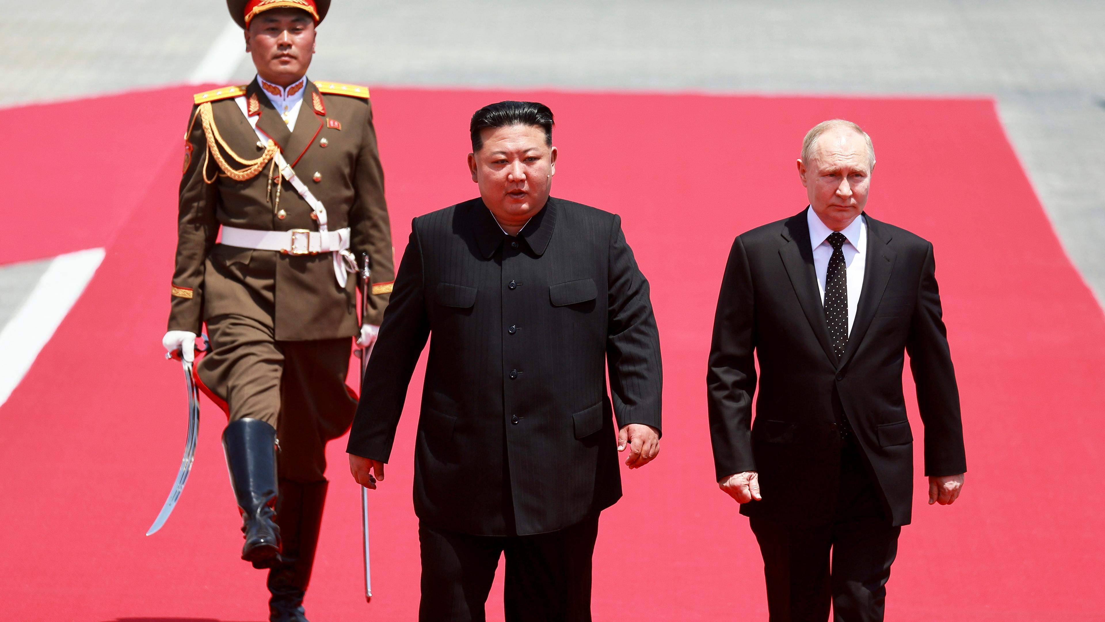 Nordkorea, Pjöngjang: Auf diesem von der staatlichen russischen Nachrichtenagentur Sputnik via AP veröffentlichten Foto nehmen der russische Präsident Wladimir Putin (r) und der nordkoreanische Staatschef Kim Jong Un an der offiziellen Begrüßungszeremonie auf dem Kim-Il-Sung-Platz teil.