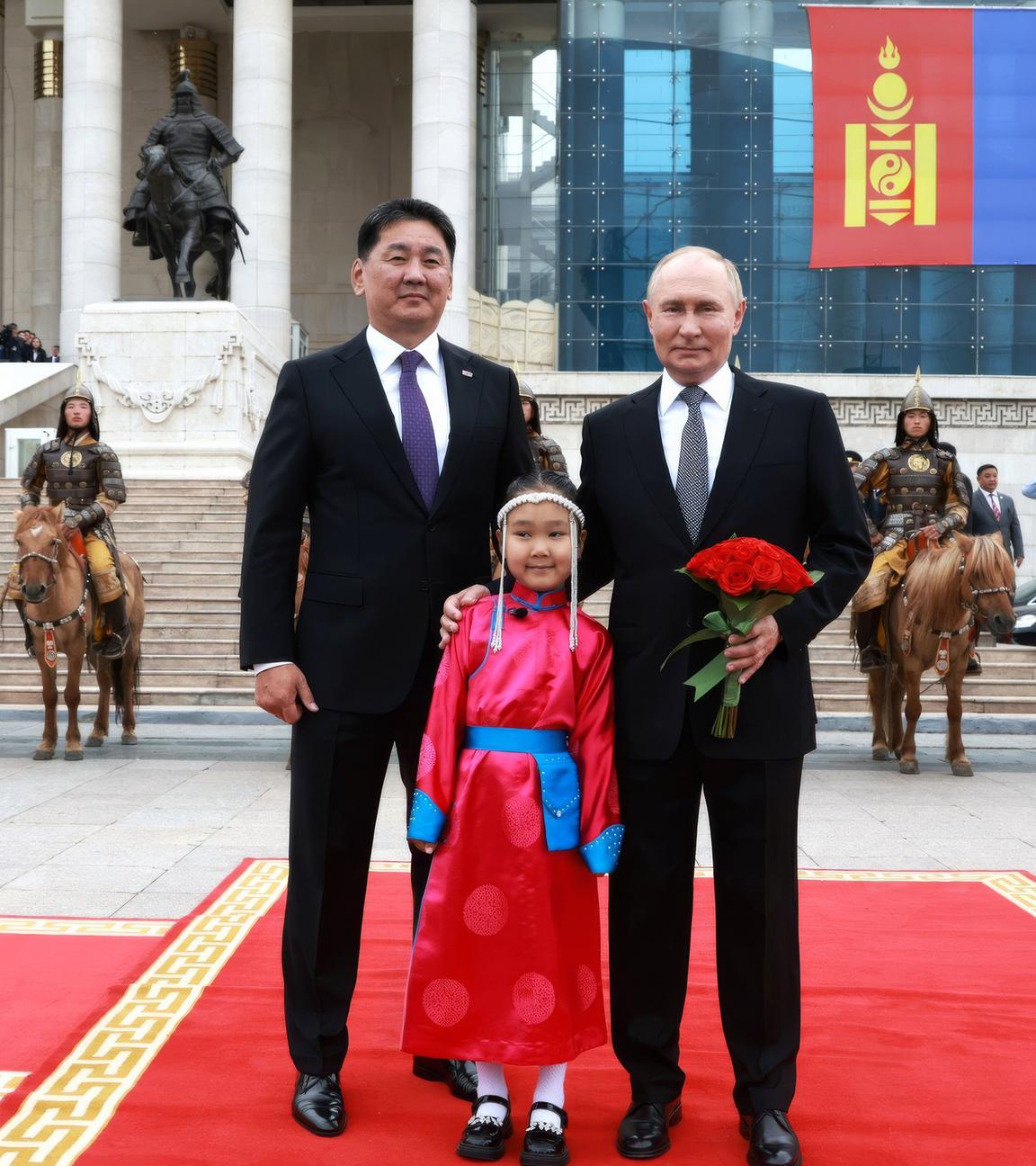 Archiv:  Der russische Präsident Wladimir Putin (r)posiert mit dem mongolischen Präsidenten Uchnaagiin Chürelsüch und einem jungen Blumenmädchen während der Ankunftszeremonie im Regierungspalast auf dem Sukhbaatar-Platz am 03.09.2024 in Ulan-Bator, Mongolei