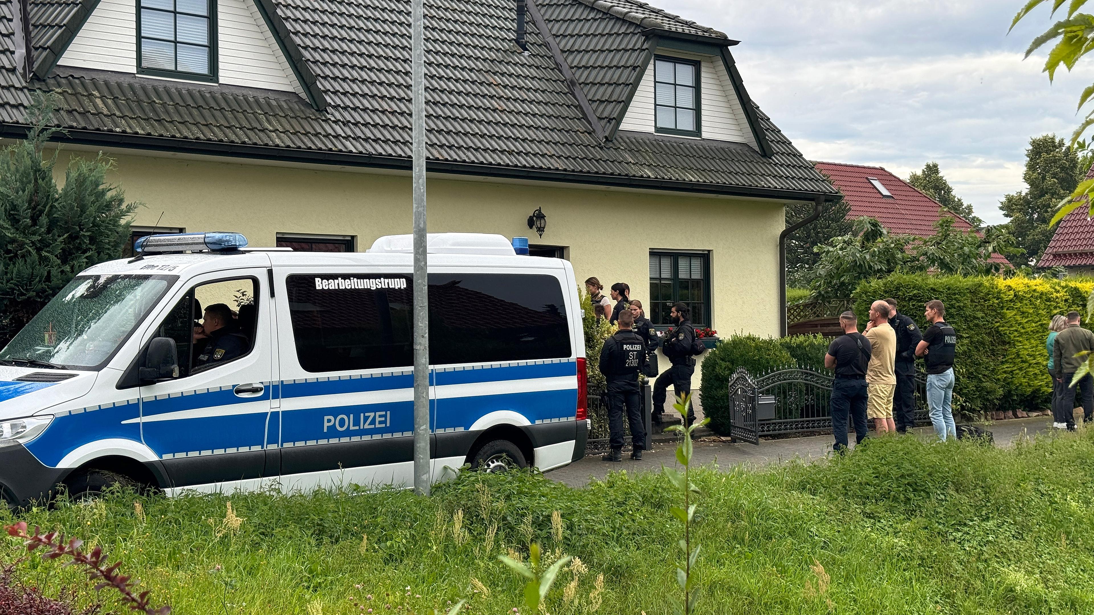 Polizisten stehen vor einem Einfamilienhaus auf der Straße am 16.07.2024 in Magdeburg (Sachsen-Anhalt)