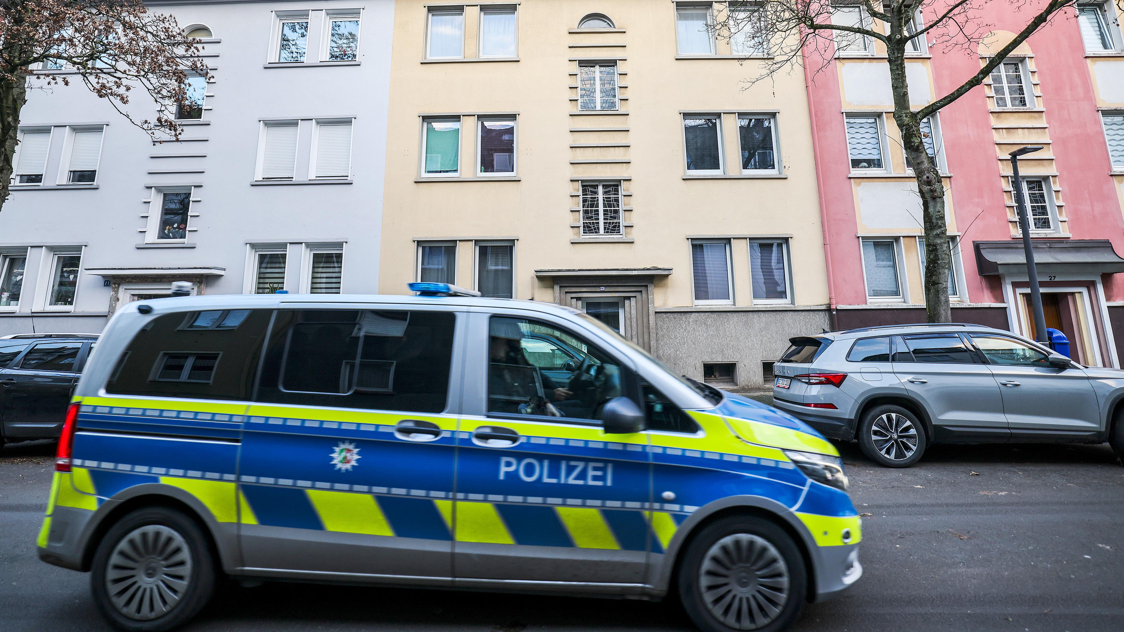 Ein Polizeiauto fährt durch eine Straße in Gelsenkirchen, in der es am Morgen zu einem Polizeieinsatz im Zusammenhang mit der Razzia gegen ein Schleuser-Netzwerk kam