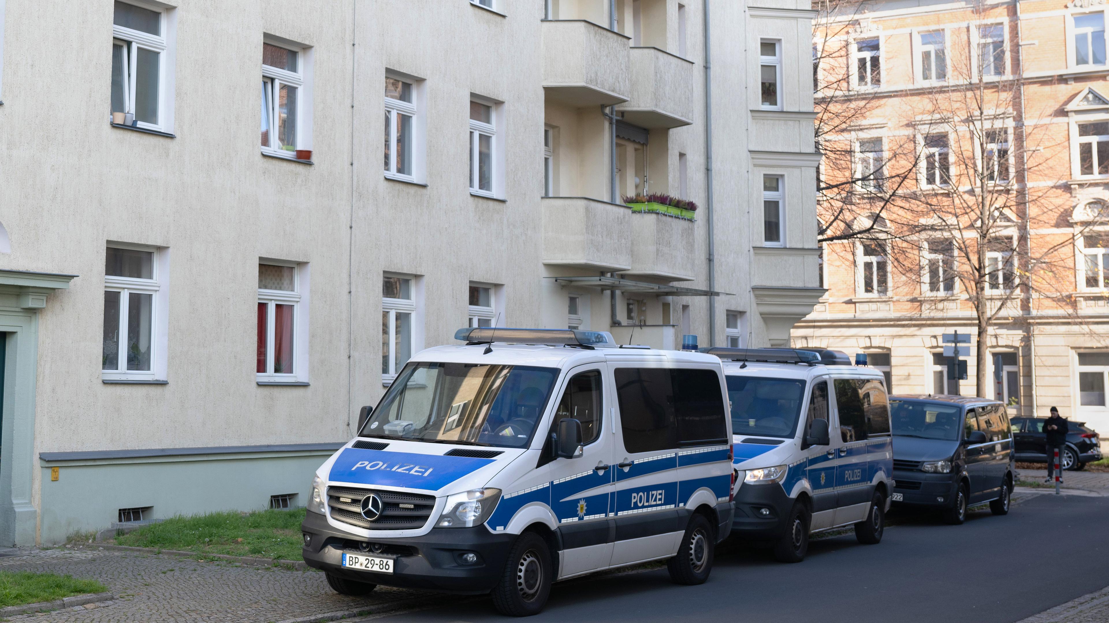 Einsatzfahrzeuge der Polizei stehen während einer Razzia gegen mutmaßliche Rechtsextreme im Dresdner Stadtteil Cotta vor einem Wohnhaus.