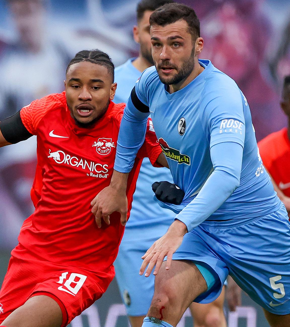 Leipzigs Christopher Nkunku (l) und Freiburgs Manuel Gulde im Duell am 05.03.2022 in Leipzig.