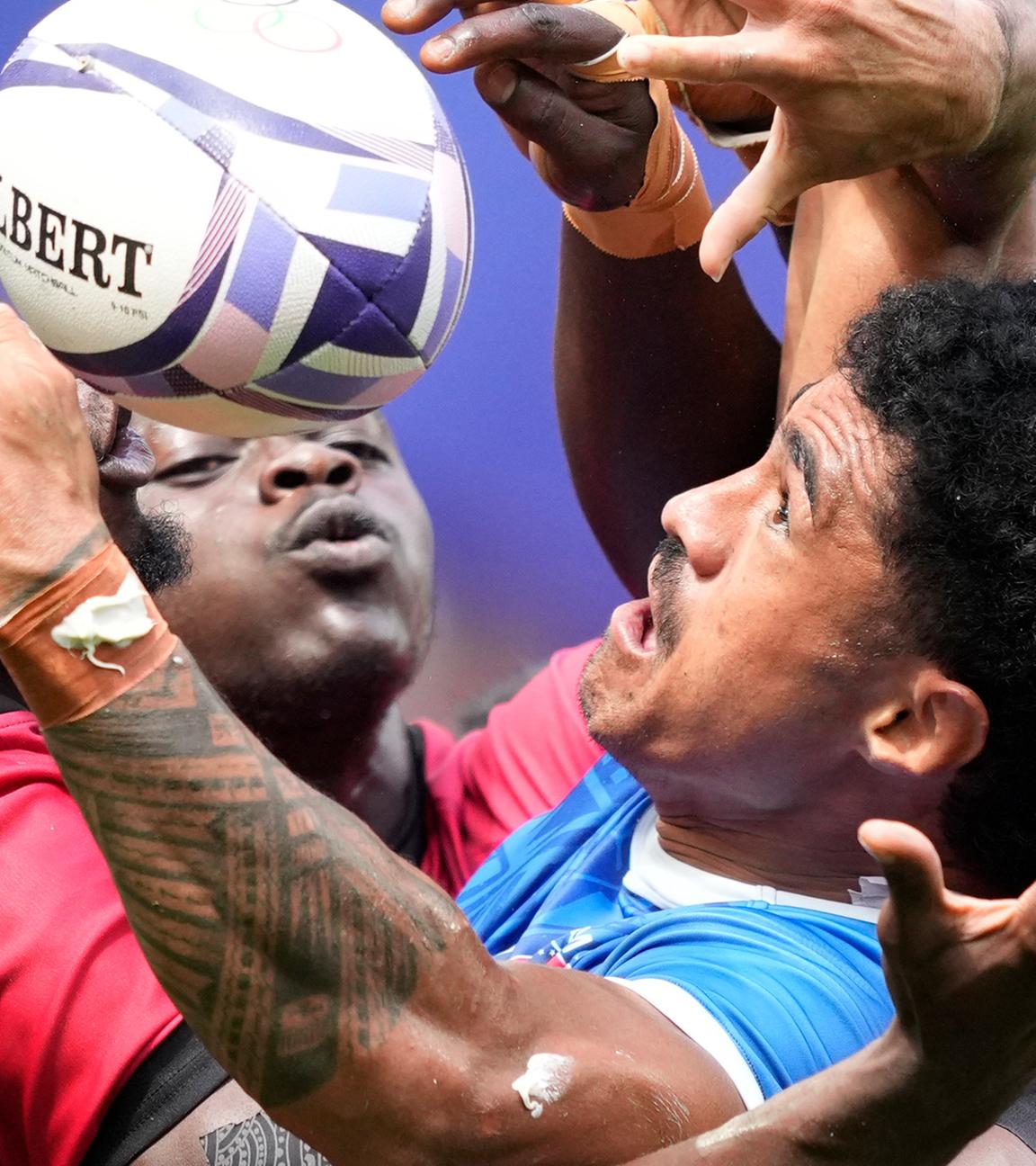 Samoas Vaa Apelu Maliko (M) in Aktion gegen Kenias Vincent Onyala (l) und Kenias Nygel Pettersan Amaitsa (r) während des Rugby Sevens.