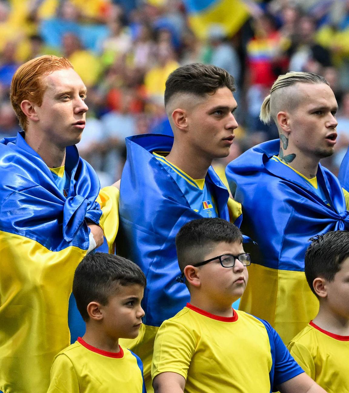 Die Spieler der Ukraine stellen sich vor dem Fußballspiel der UEFA Euro 2024 Gruppe E zwischen Rumänien und der Ukraine in der Münchner Fußballarena am 17. Juni 2024 auf