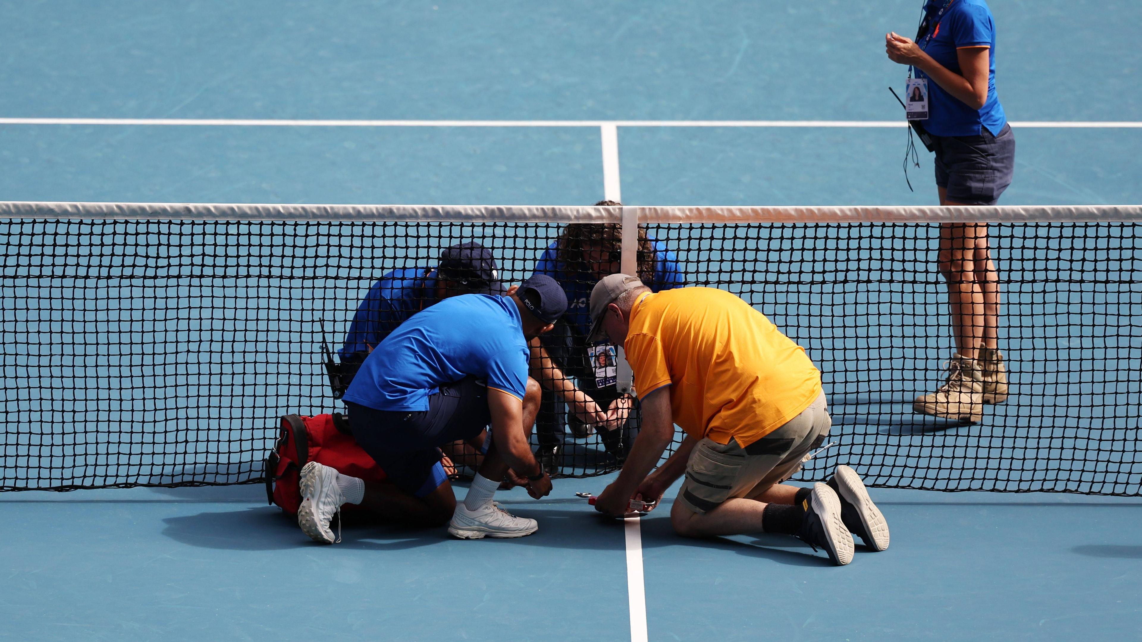 Ein Handwerker repariert das kaputte Netz während des Spiels der vierten Runde zwischen Rune und Sinner Australian Open.