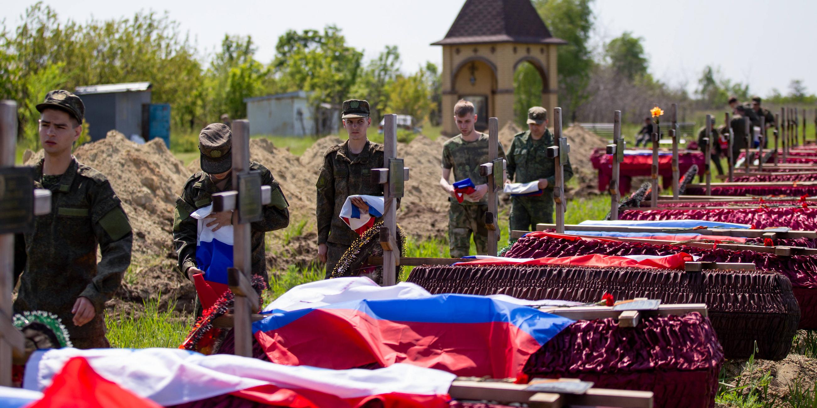 Russische Soldaten und Särge 