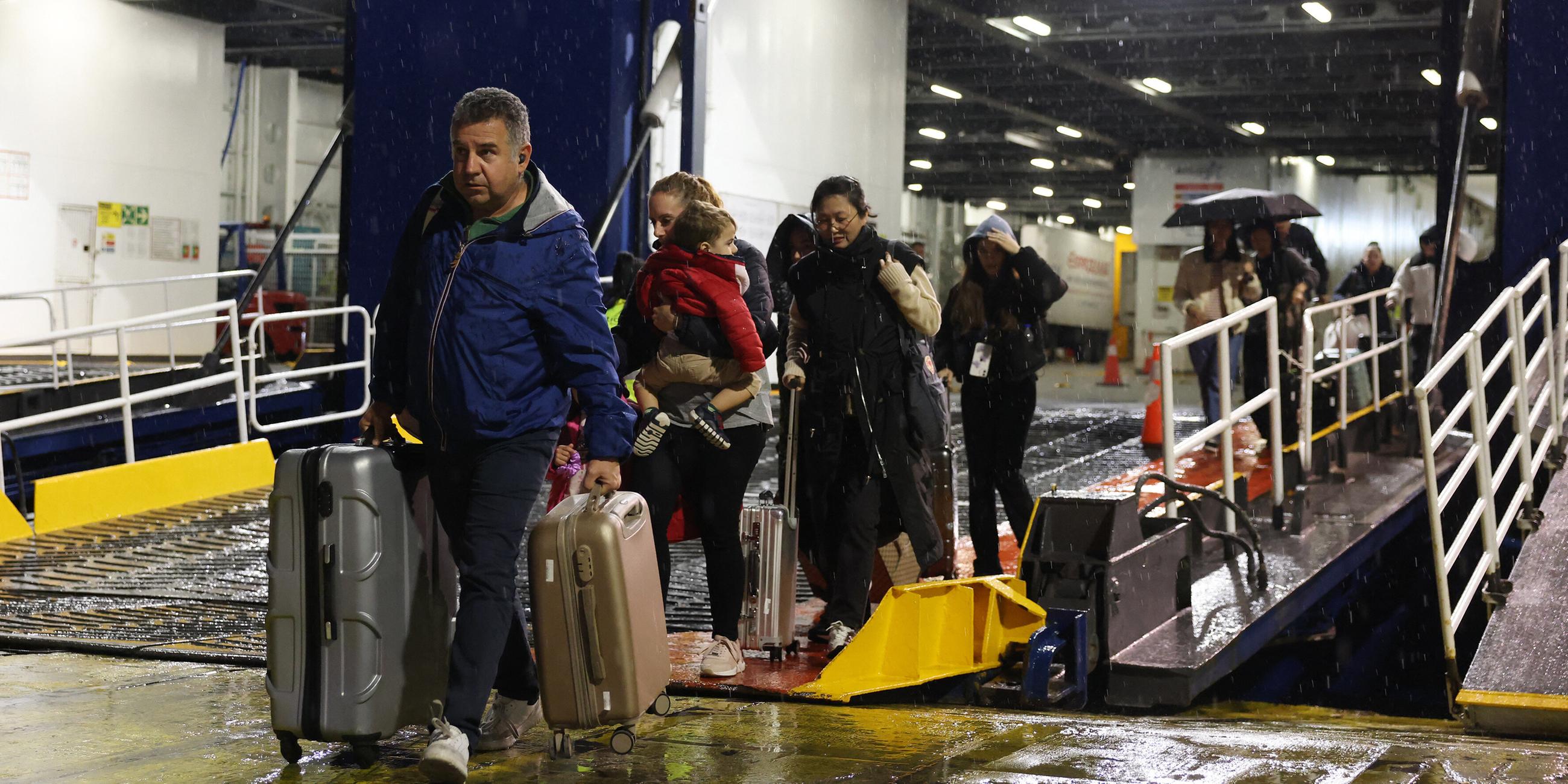 Menschen verlassen eine Fähre in Piraeus