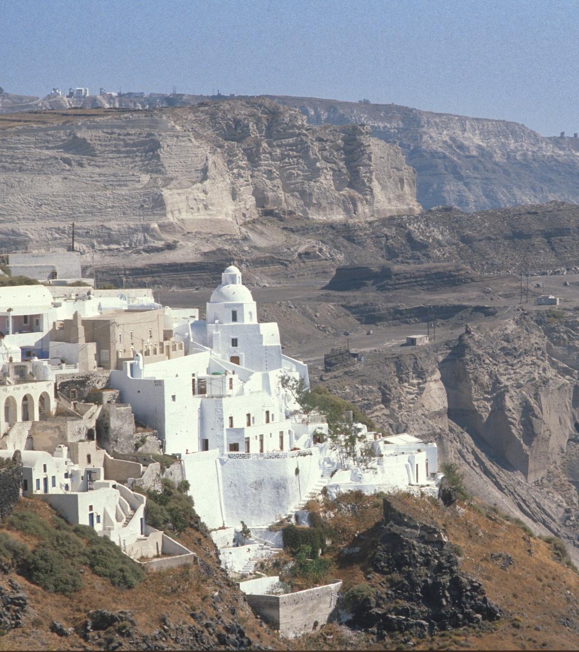 Gebäude auf der Insel Santorini, im Hintergrund Felshänge.