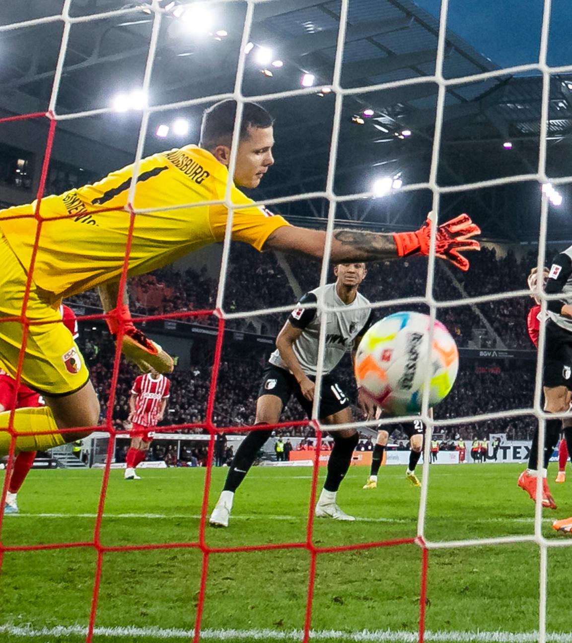 Freiburgs Lienhart (verdeckt) macht das Tor zum 3:1 gegen Augsburgs Torwart Rafal Gikiewicz (l).