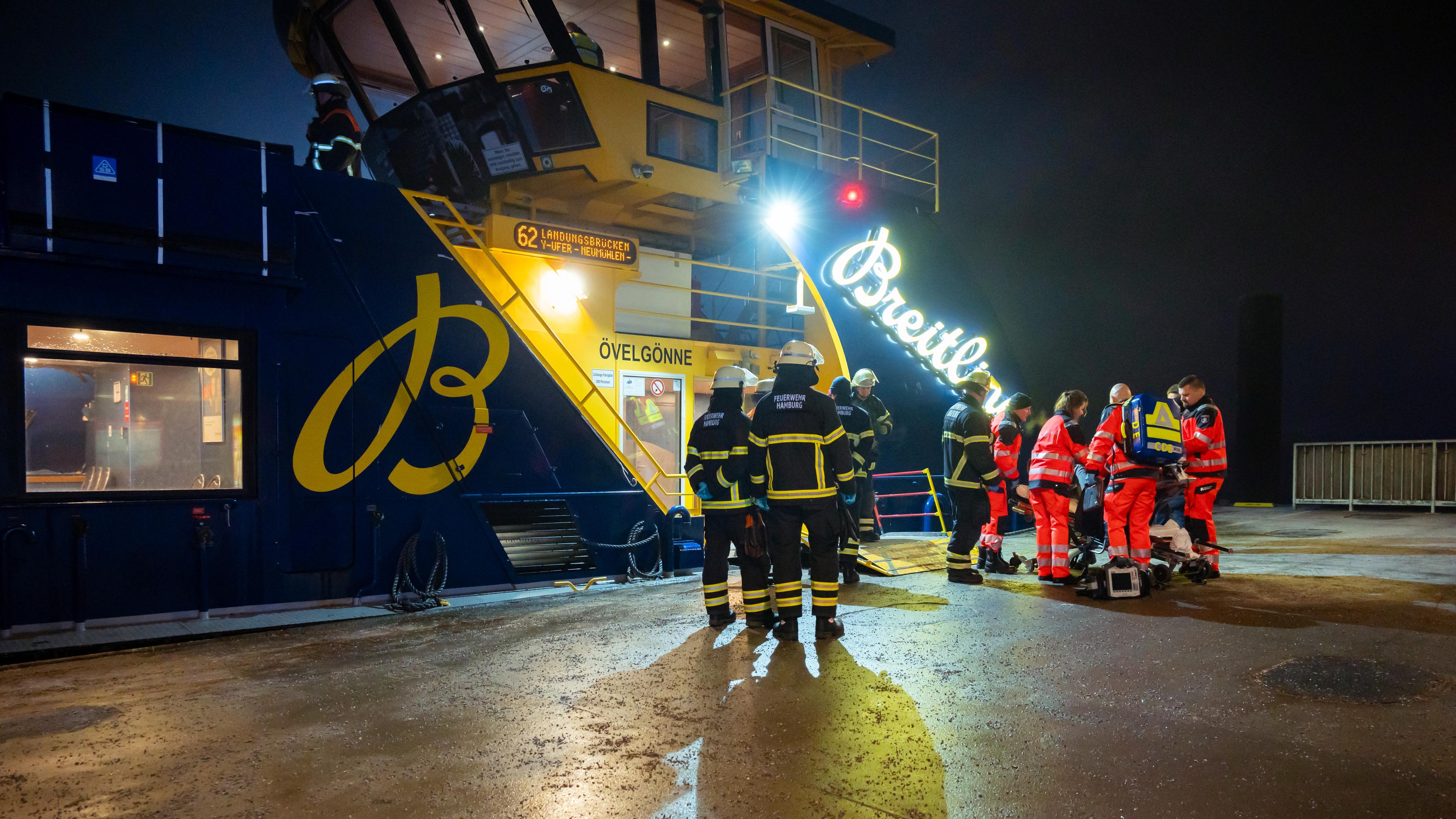 Einsatzkräfte arbeiten auf der beschädigten Fähre, die am Anleger Dockland festgemacht hat. Auf der Elbe ist eine Schute gegen eine Fähre geprallt, dabei wurden mehrere Menschen verletzt.