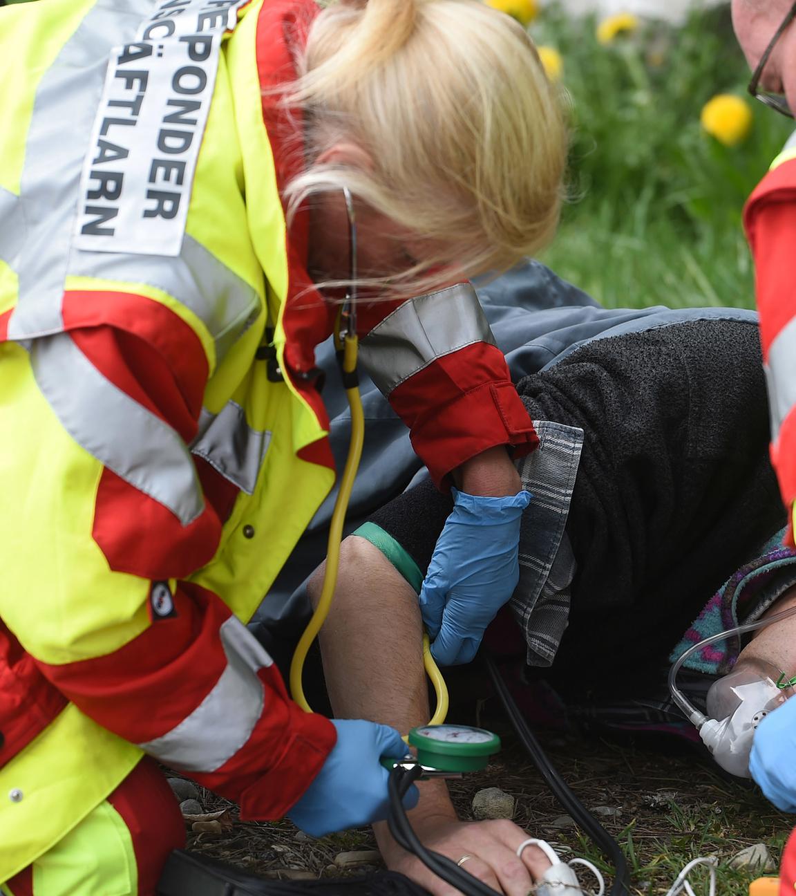 Helfer einer First Responder Einheit demonstrieren bei einer Einsatzübung auf einem Feldweg die versorgung eines patienten