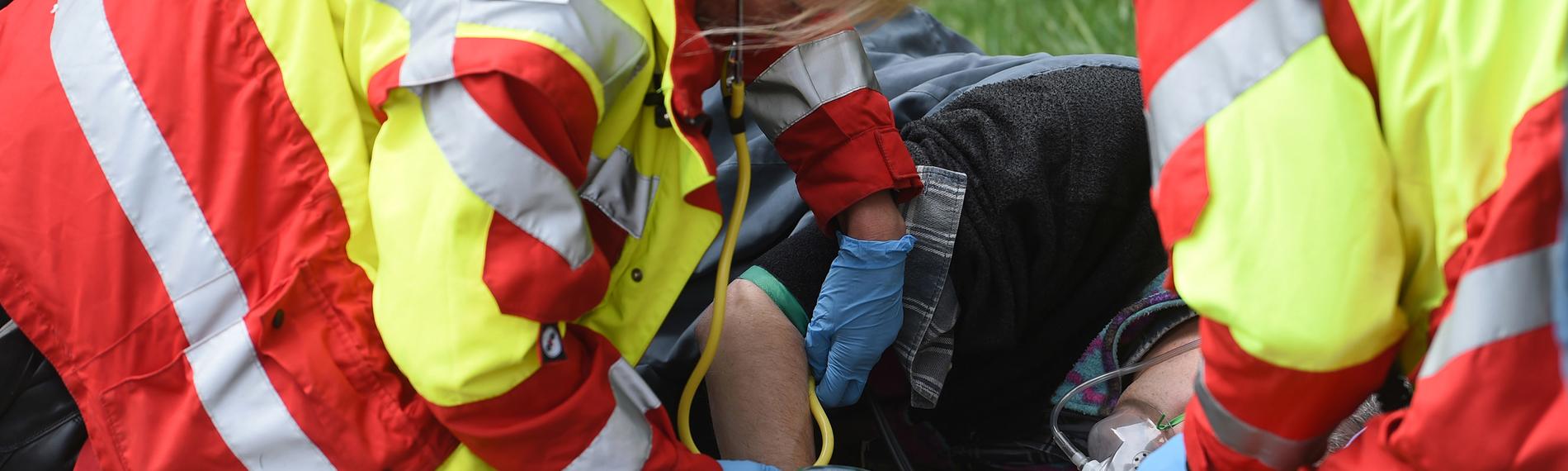 Helfer einer First Responder Einheit demonstrieren bei einer Einsatzübung auf einem Feldweg die versorgung eines patienten