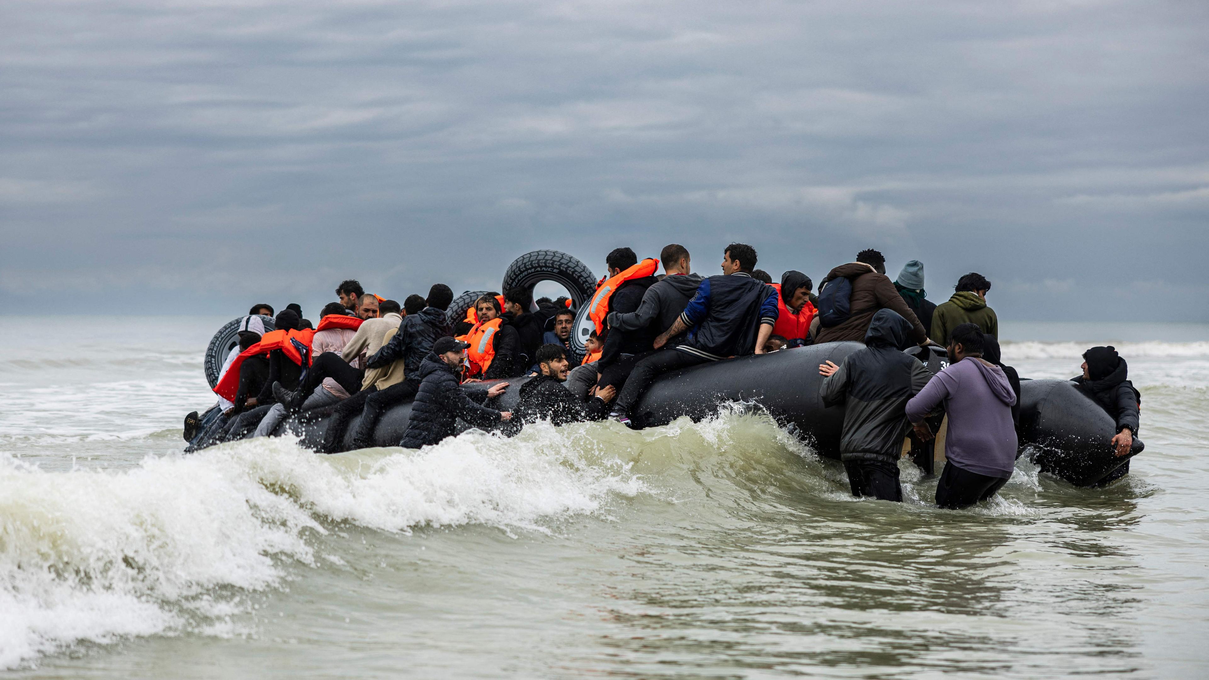 Migranten besteigen das Schlauchboot eines Schmugglers und versuchen, den Ärmelkanal zu überqueren