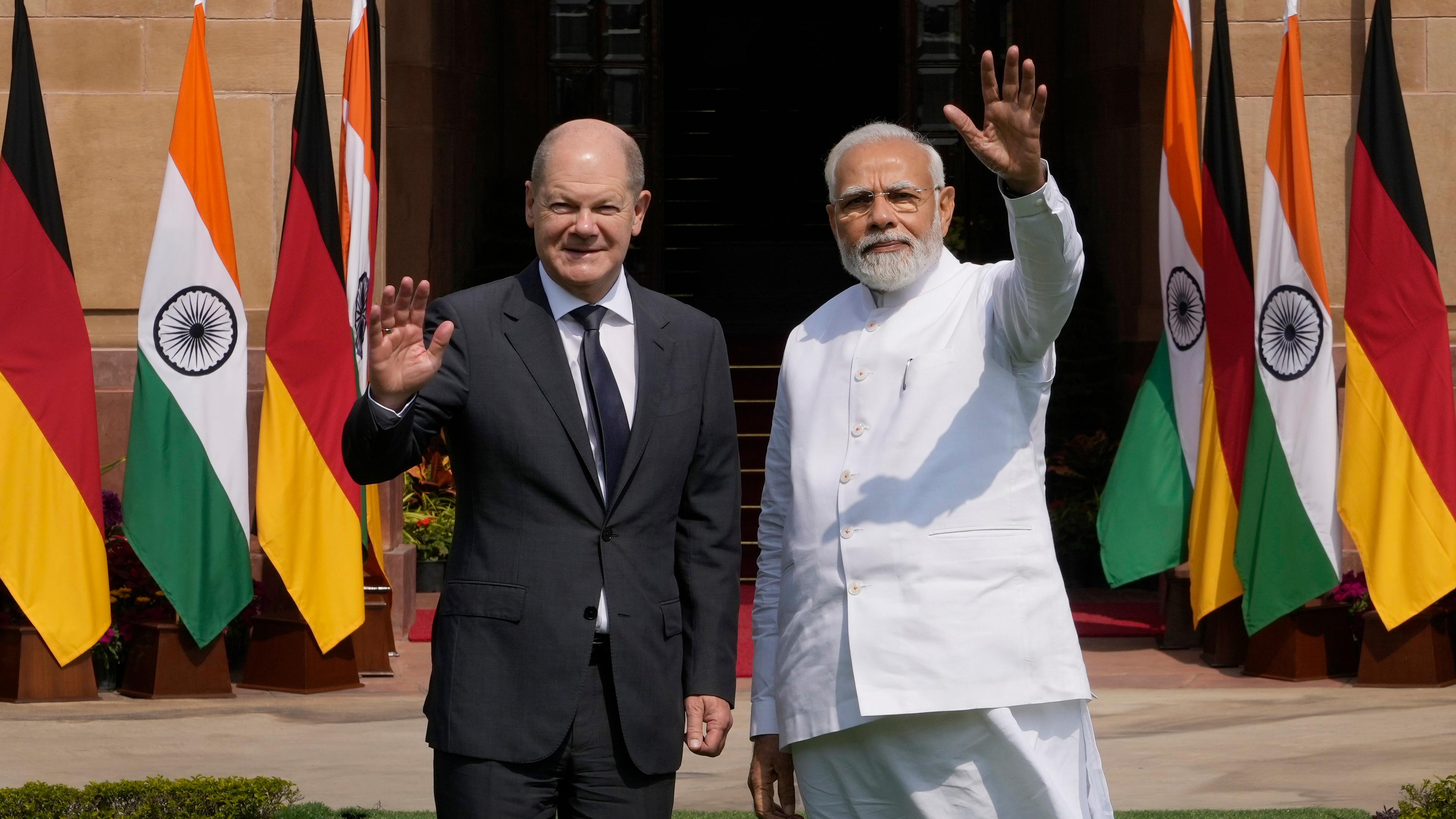 Bundeskanzler Olaf Scholz und der indische Premierminister Narendra Modi winken der Presse zu, bevor sie sich ihrem Gespräch in Neu Deli widmen. 