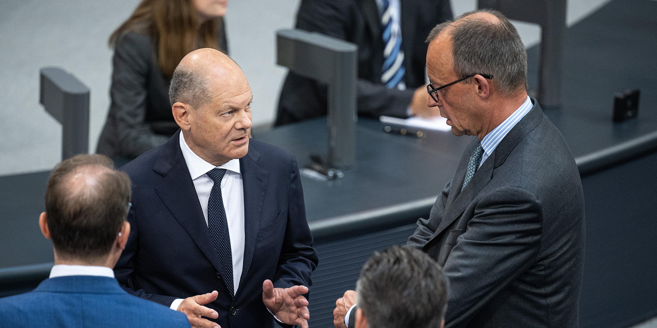 Olaf Scholz im Gespräch mit Friedrich Merz