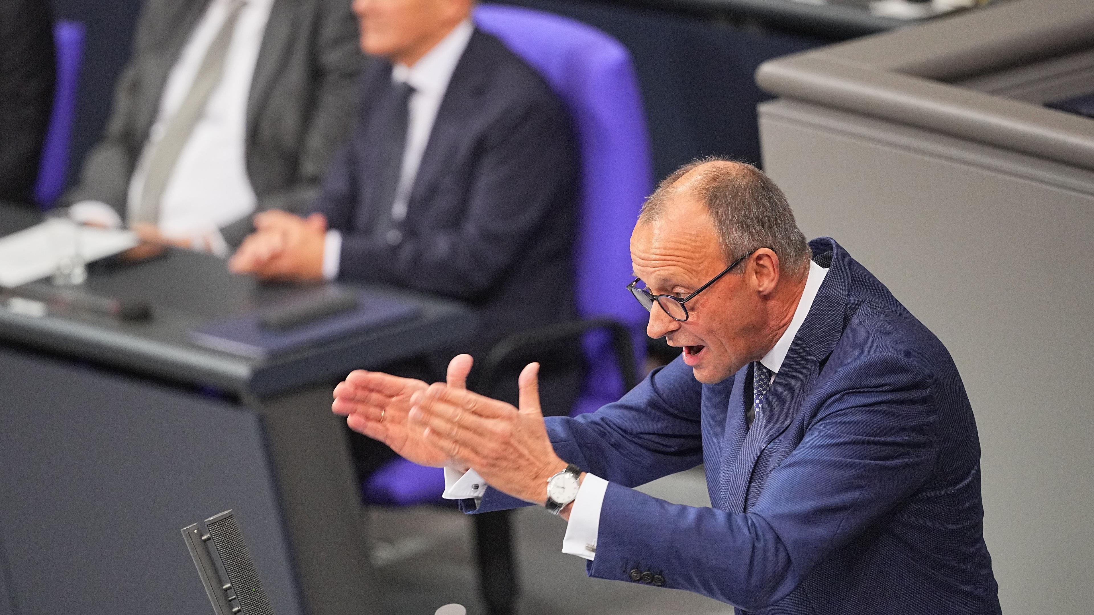 13.11.2024, Berlin: Friedrich Merz, CDU-Bundesvorsitzender und Unionsfraktionsvorsitzender, spricht nach der Regierungserklärung von Bundeskanzler Olaf Scholz (SPD, l).