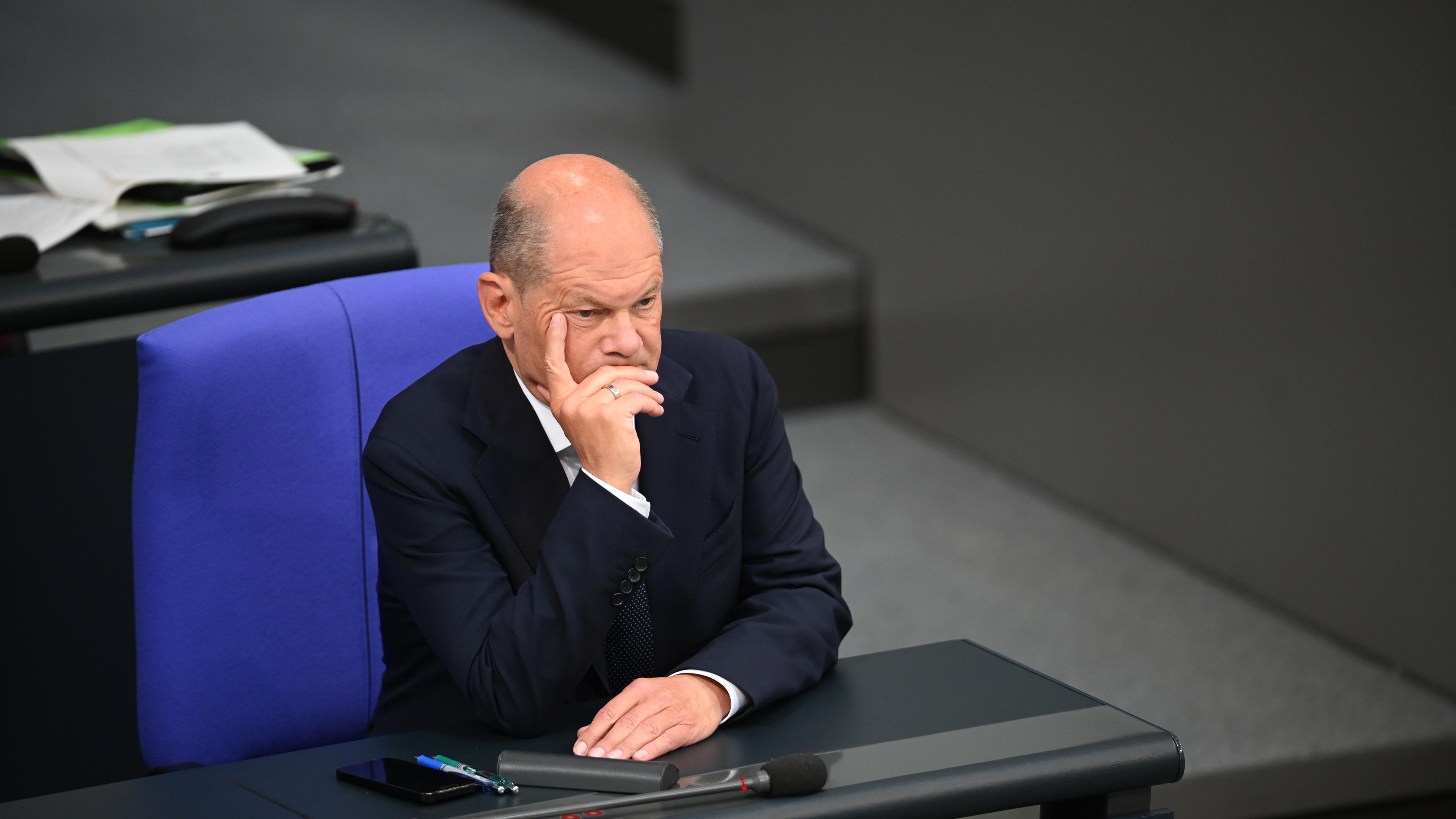 Bundeskanzler Olaf Scholz (SPD), sitzt im Bundestag während der Debatte zur aktuellen Sicherheitslage