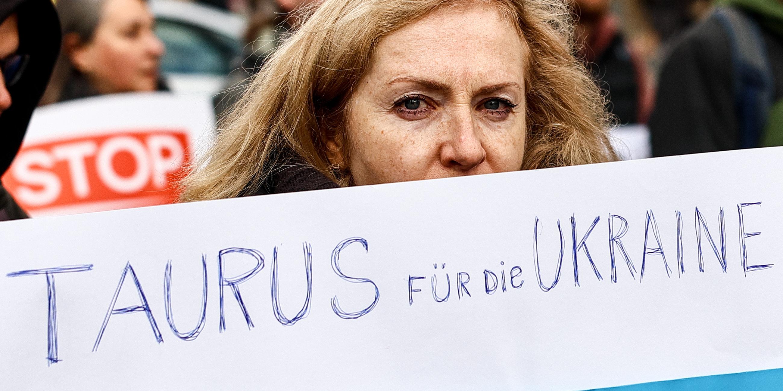 Eine Frau hält auf einer Antikriegsdemonstration in Berlin ein Plakat mit der Aufschrift "Taurus für die Ukraine".