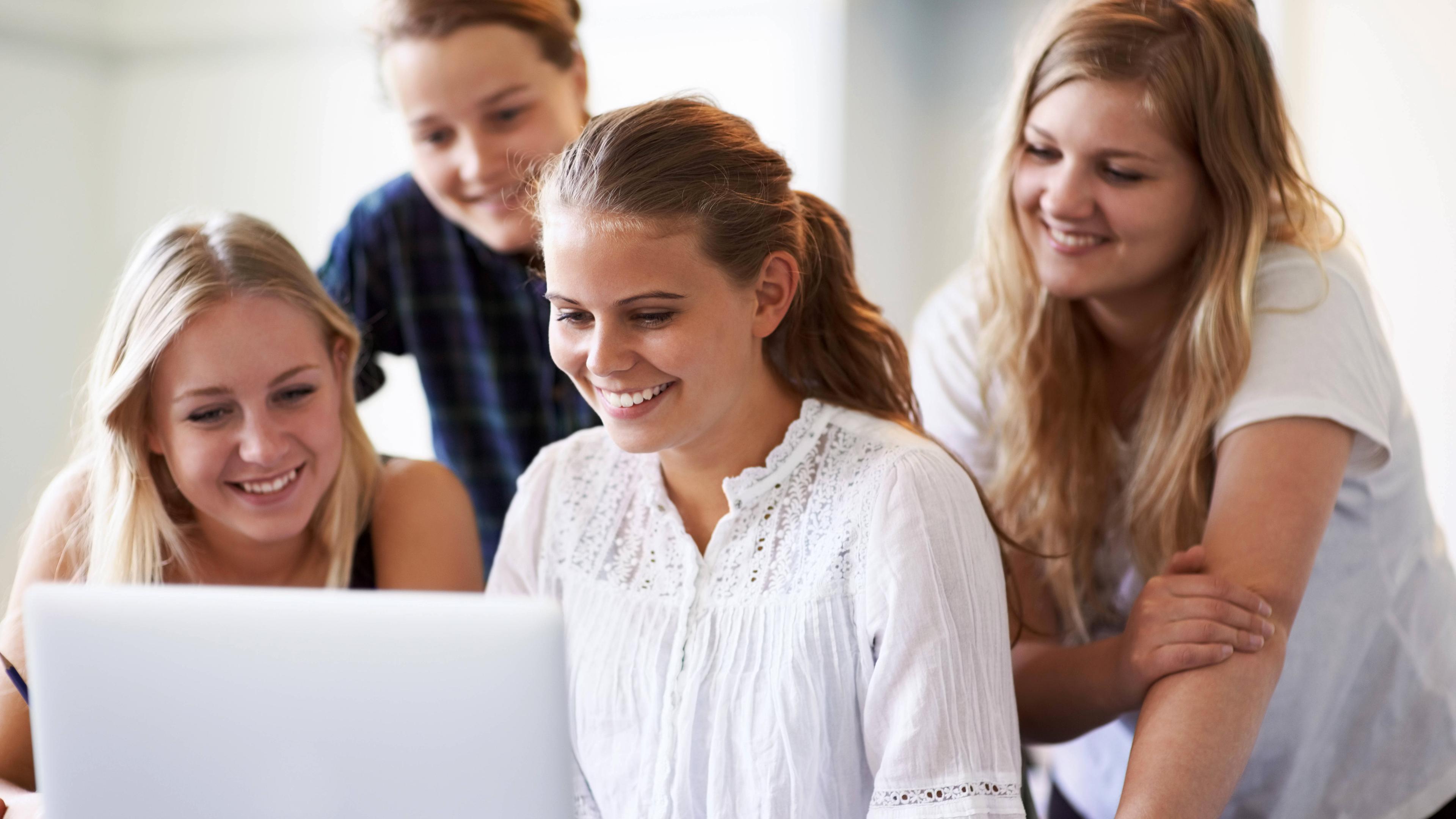 Eine Gruppe Schüler mit Laptop recherchieren und lernen zusammen mit Internet oder Website