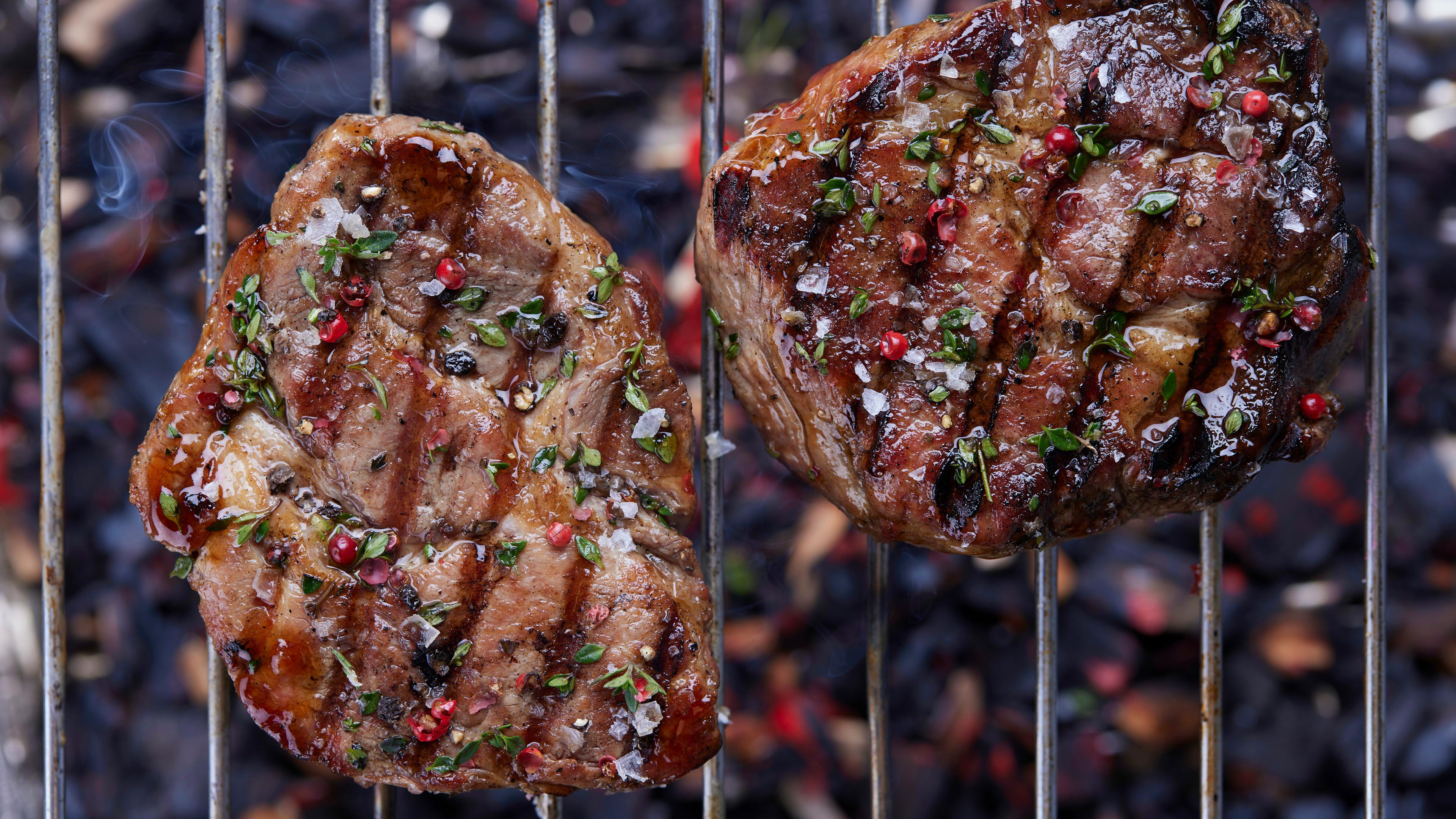 Zwei Steaks nebeneinander auf dem Grill.