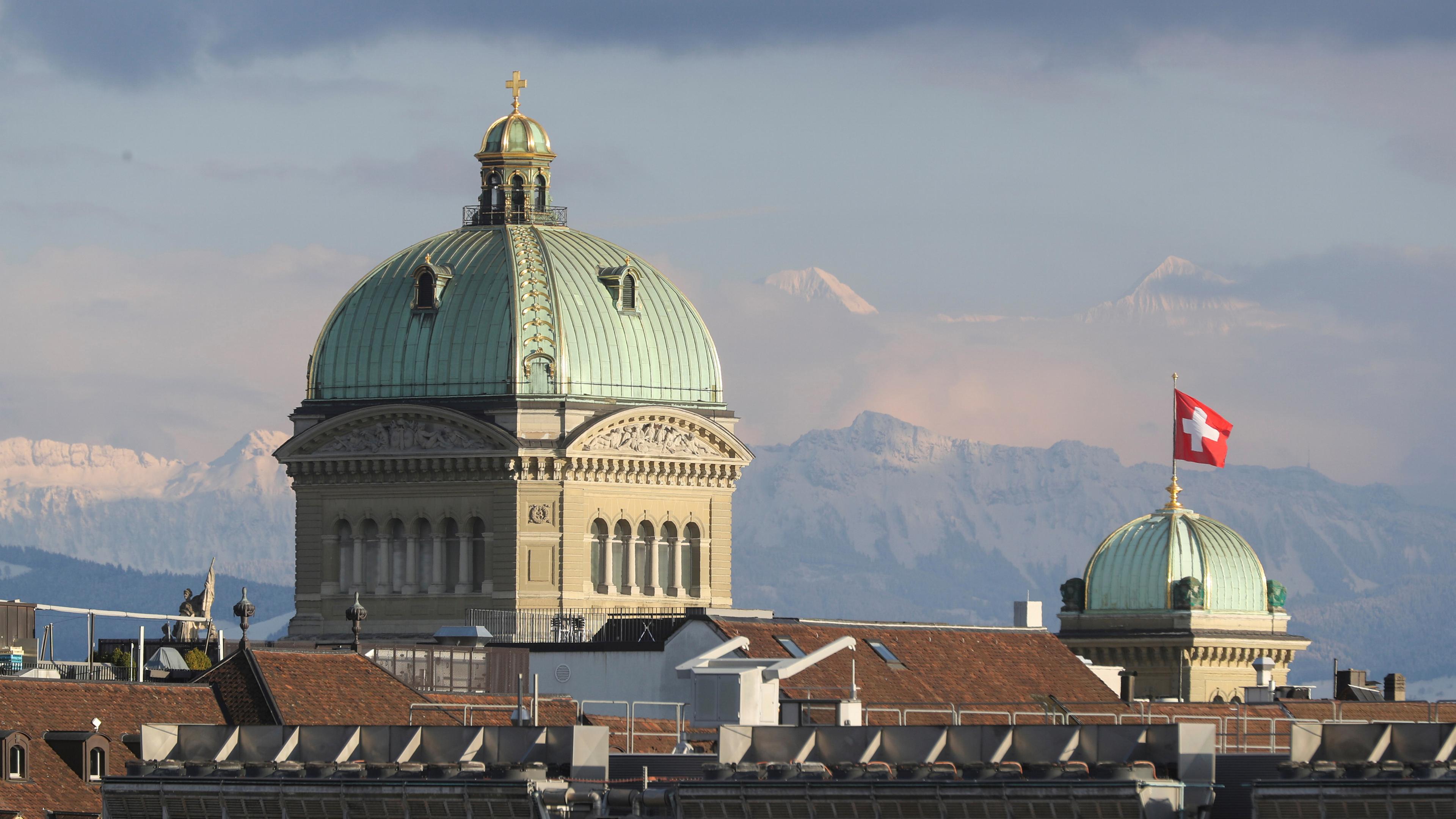 Zu sehen ist das schweizer Bundeshaus, mit den Alpen im Hintergrund.