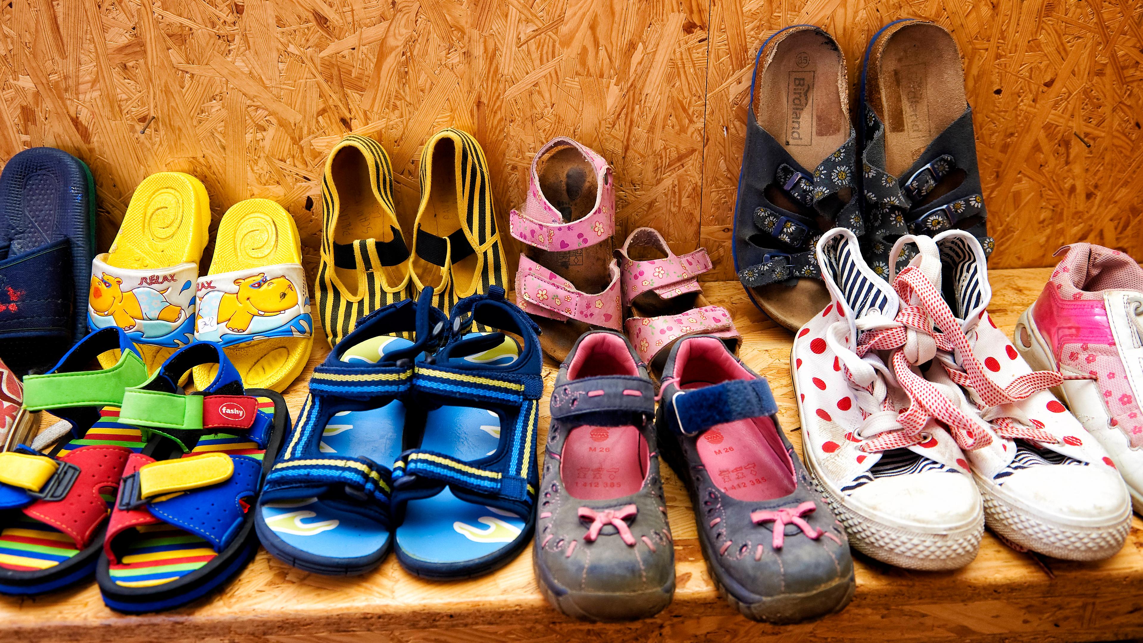 Secondhand-Schuhe für Kinder mehrerer Altersstufen liegen in der Auslage eins Seconhand-Ladens.