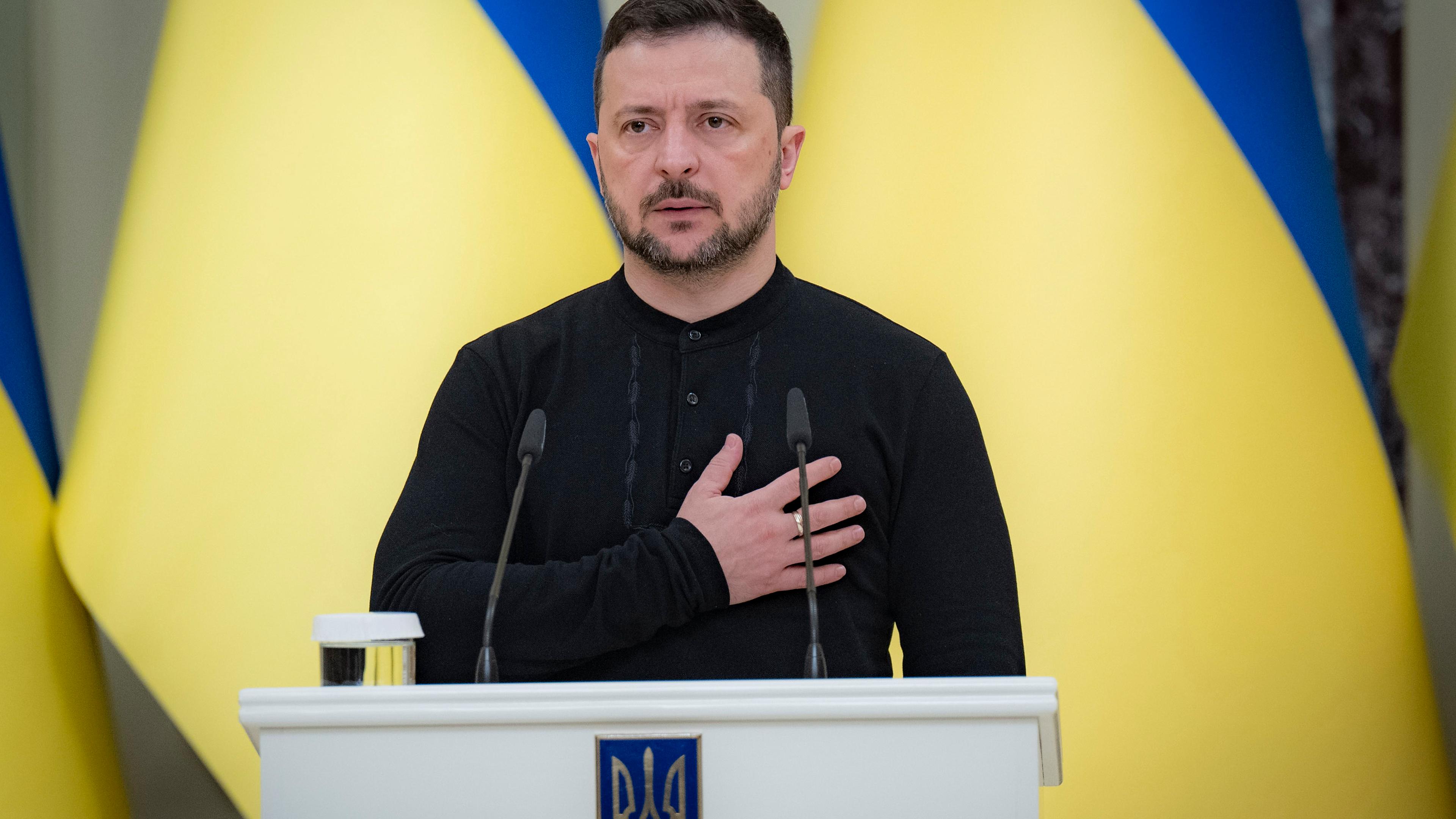 08.11.2024, Ukraine, Kiew: Wolodymyr Selenskyj, Präsident der Ukraine, steht beim Abspielen der Nationalhymne, bevor er während einer Zeremonie im Mariinskyi-Palast den Helden der Ukraine und den Familien der gefallenen Soldaten Urkunden für kostenlose Wohnungen überreicht.