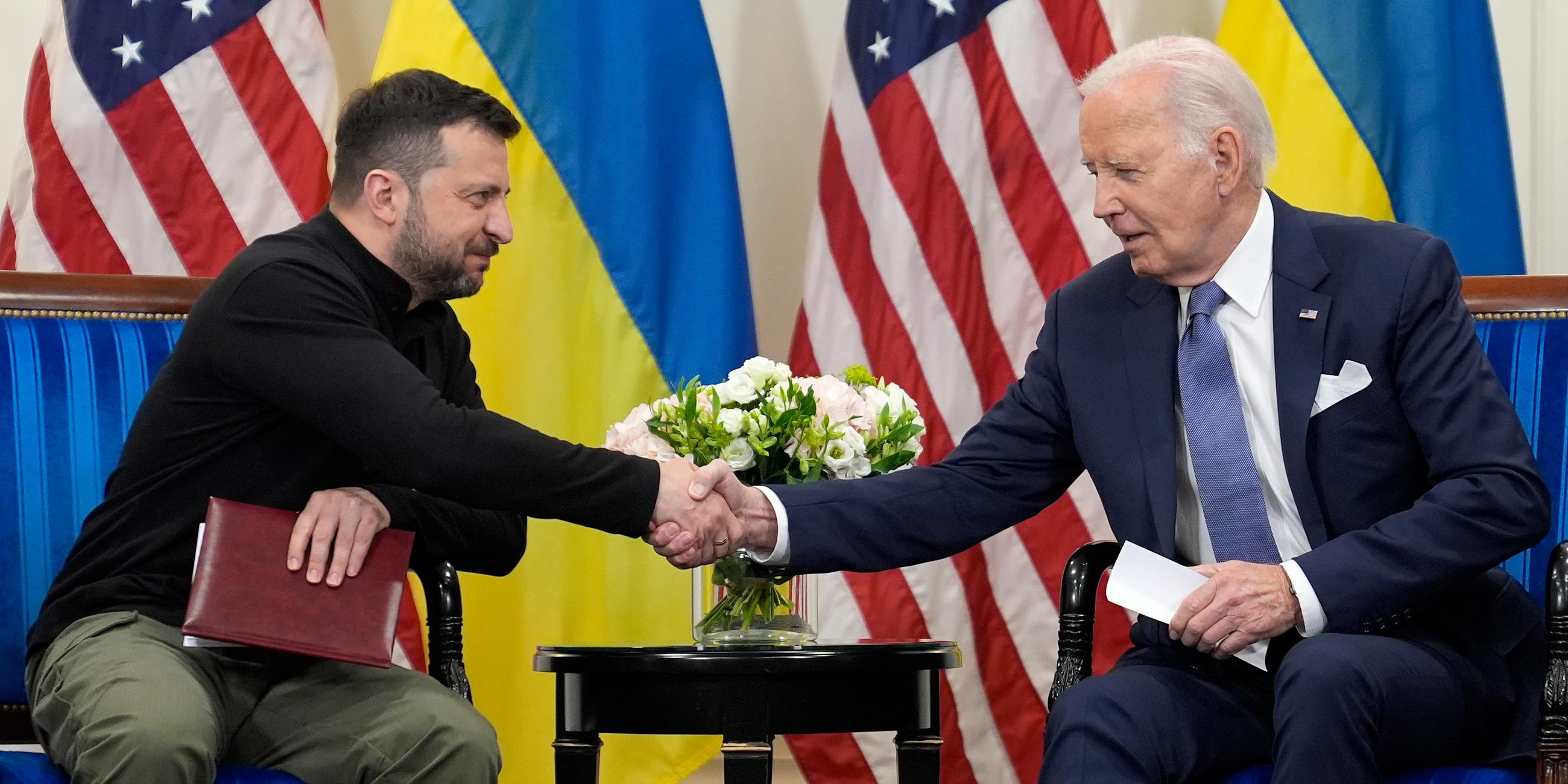 Der ukrainische Präsident Wolodymyr Selenskyj (links) schüttelt in Paris die Hand von US-Präsident Joe Biden (rechts).